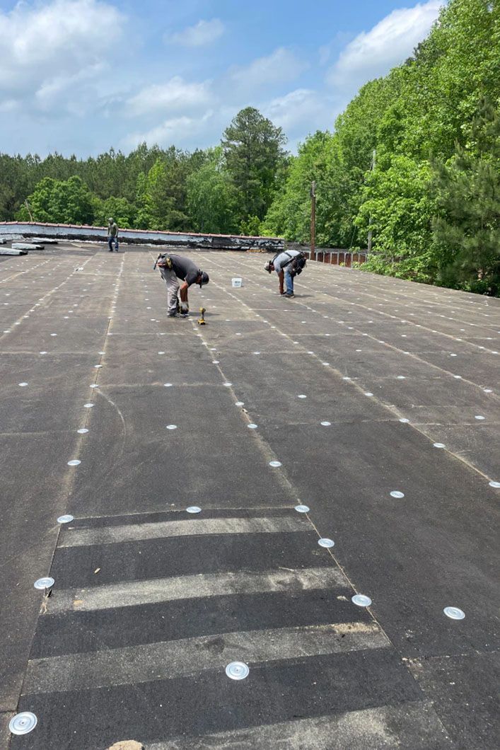 A man is working on the roof of a building.
