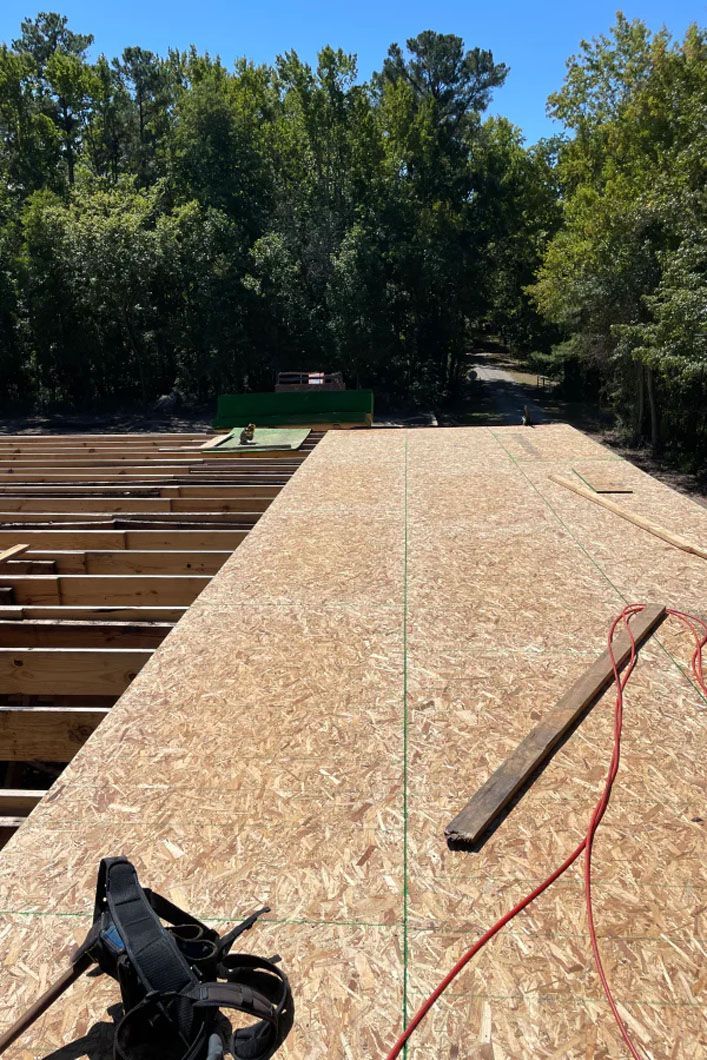 A roof is being built with wooden beams and plywood.