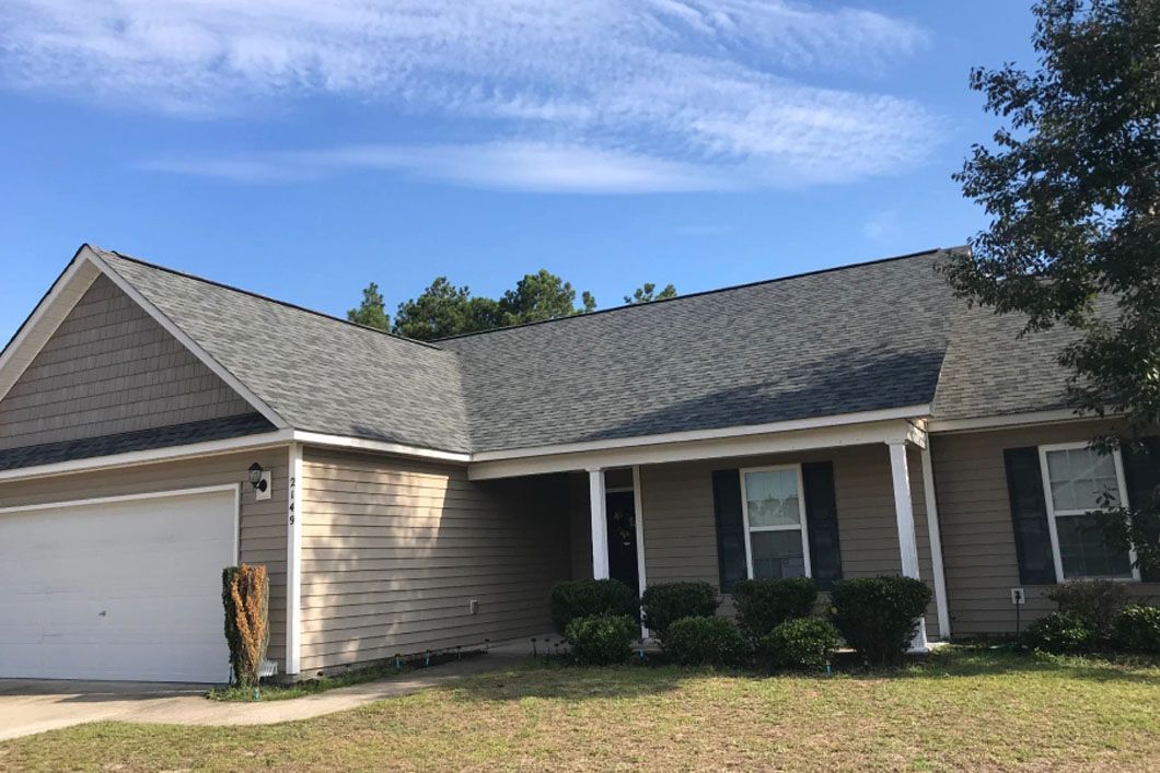 A house with a gray roof and a white garage door.