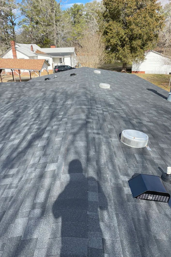 A roof with a shadow of a person on it.