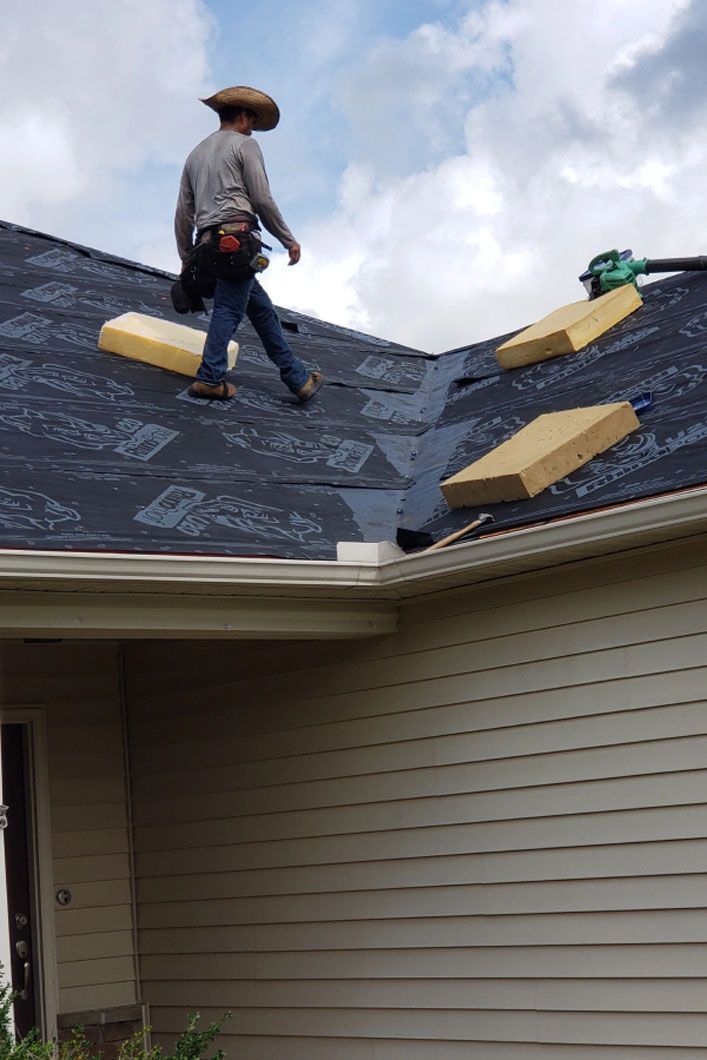 A man is standing on top of a roof.