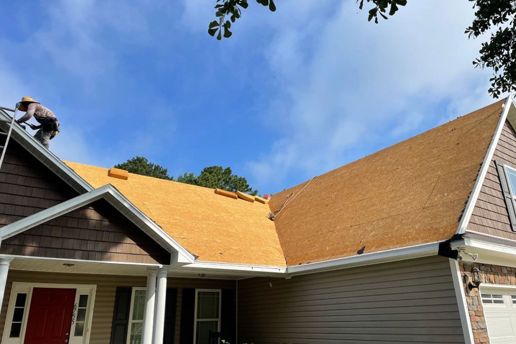A man is working on the roof of a house.