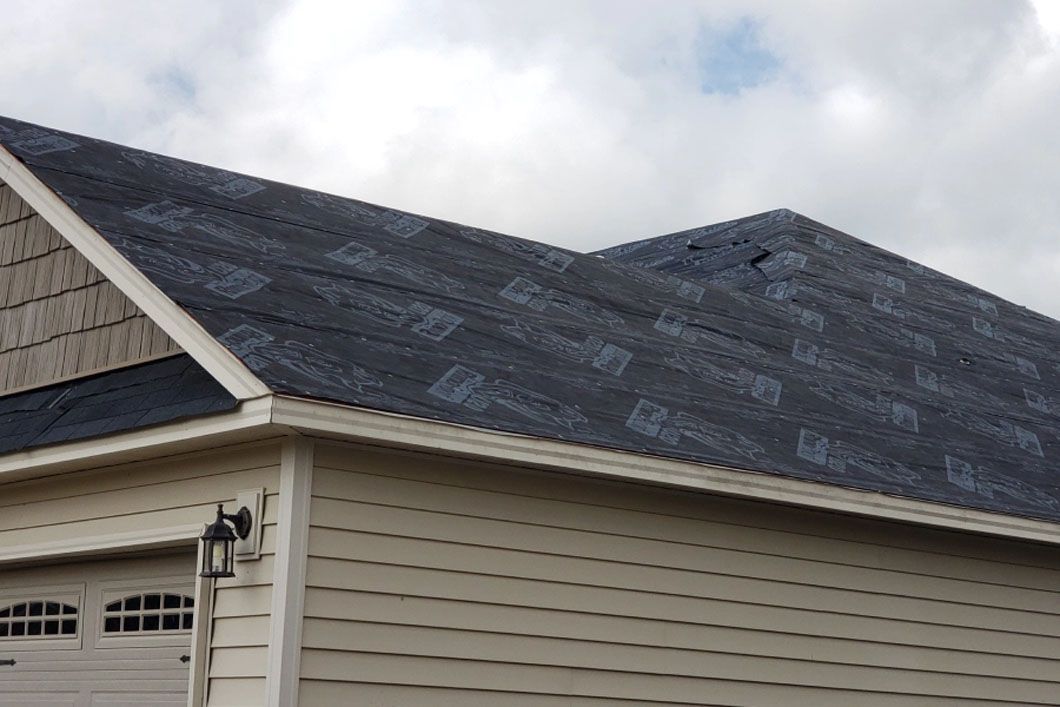 A house with a black roof and a white garage door.