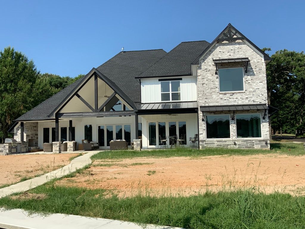 A large white house with a black roof and a lot of windows