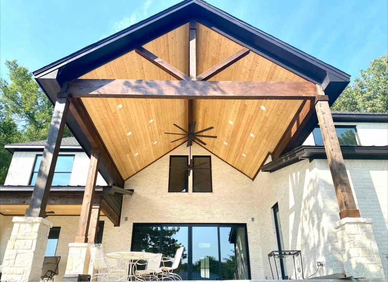 The back of a house with a wooden roof and a ceiling fan.