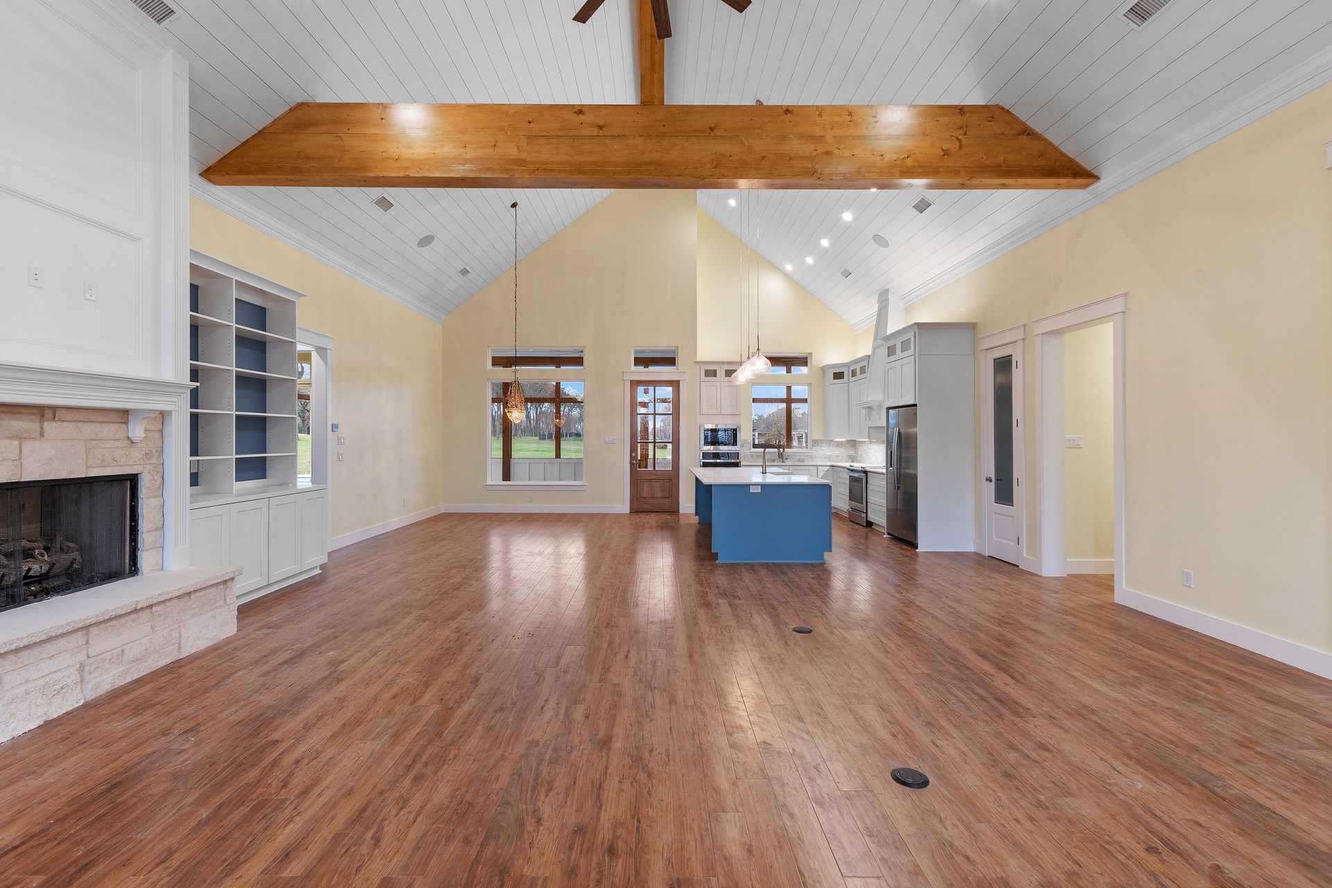 A large empty living room with hardwood floors and a fireplace.