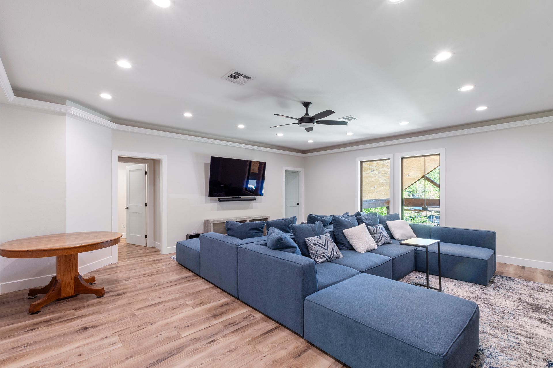 A living room with a large blue couch and a flat screen tv.
