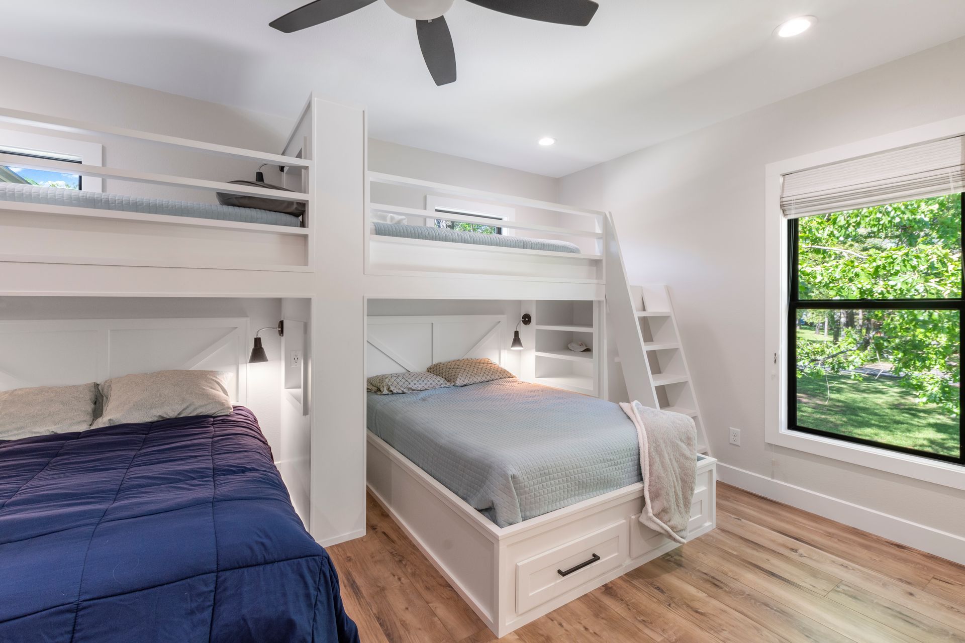 A bedroom with two bunk beds and a ceiling fan.