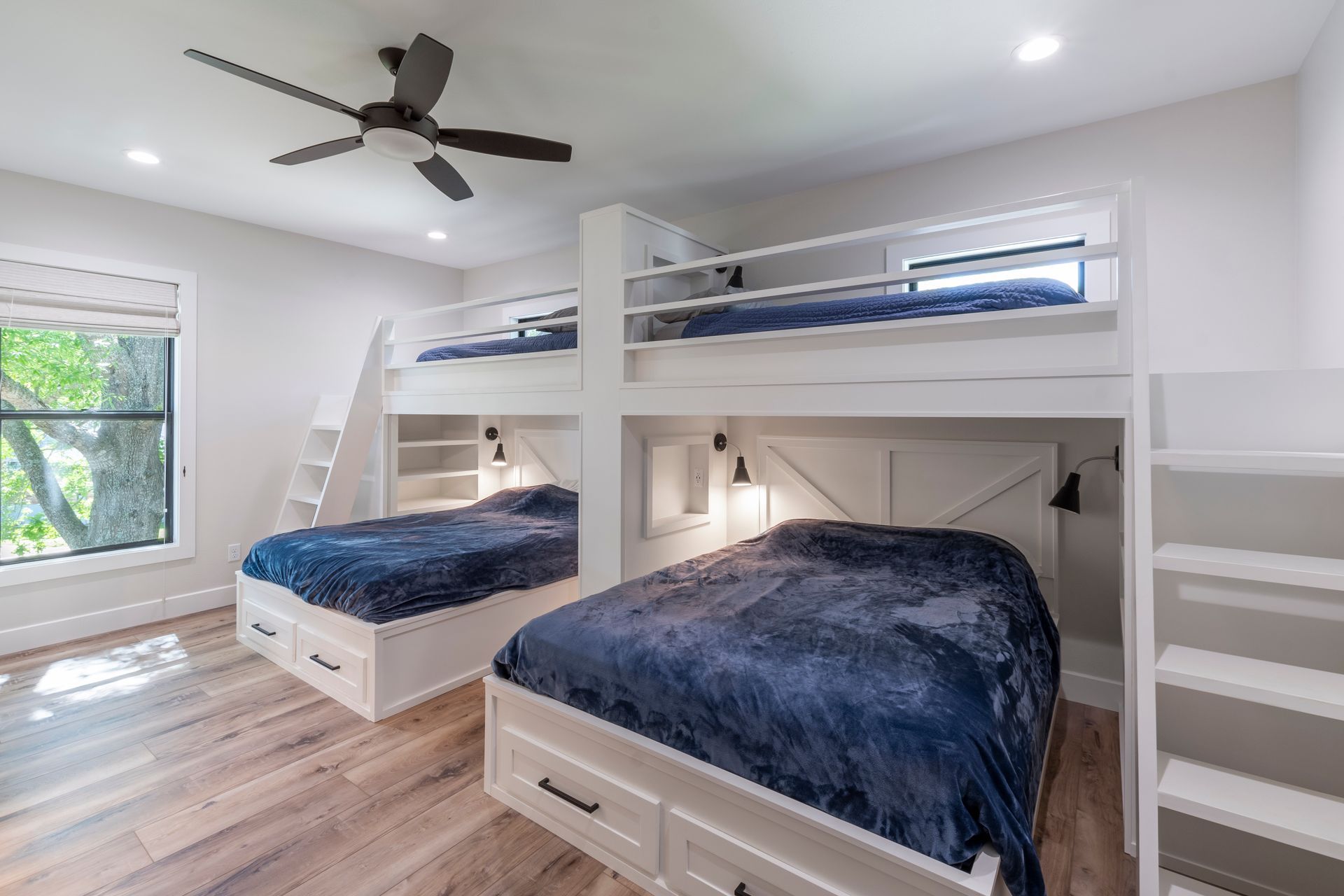 A bedroom with three bunk beds and a ceiling fan.