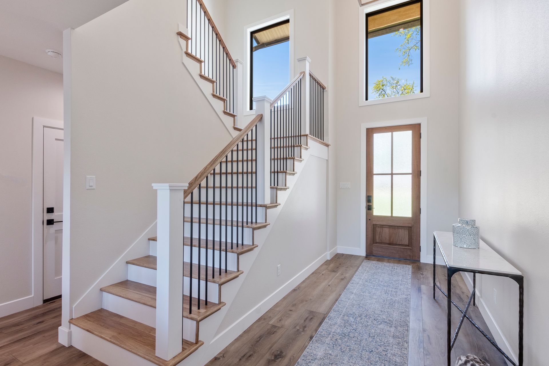A hallway with stairs leading up to the second floor of a house.