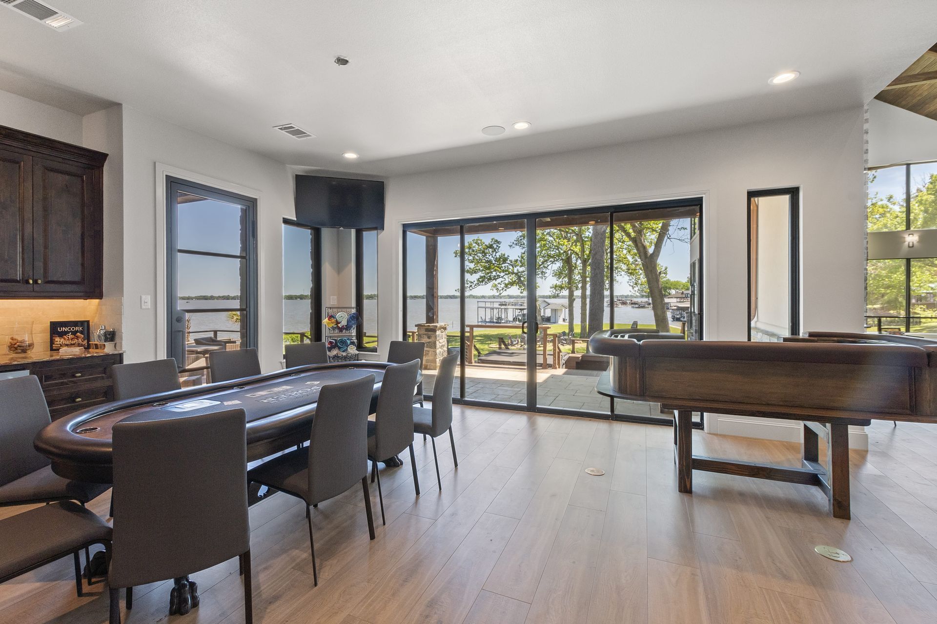 A large room with a table and chairs and a pool table.
