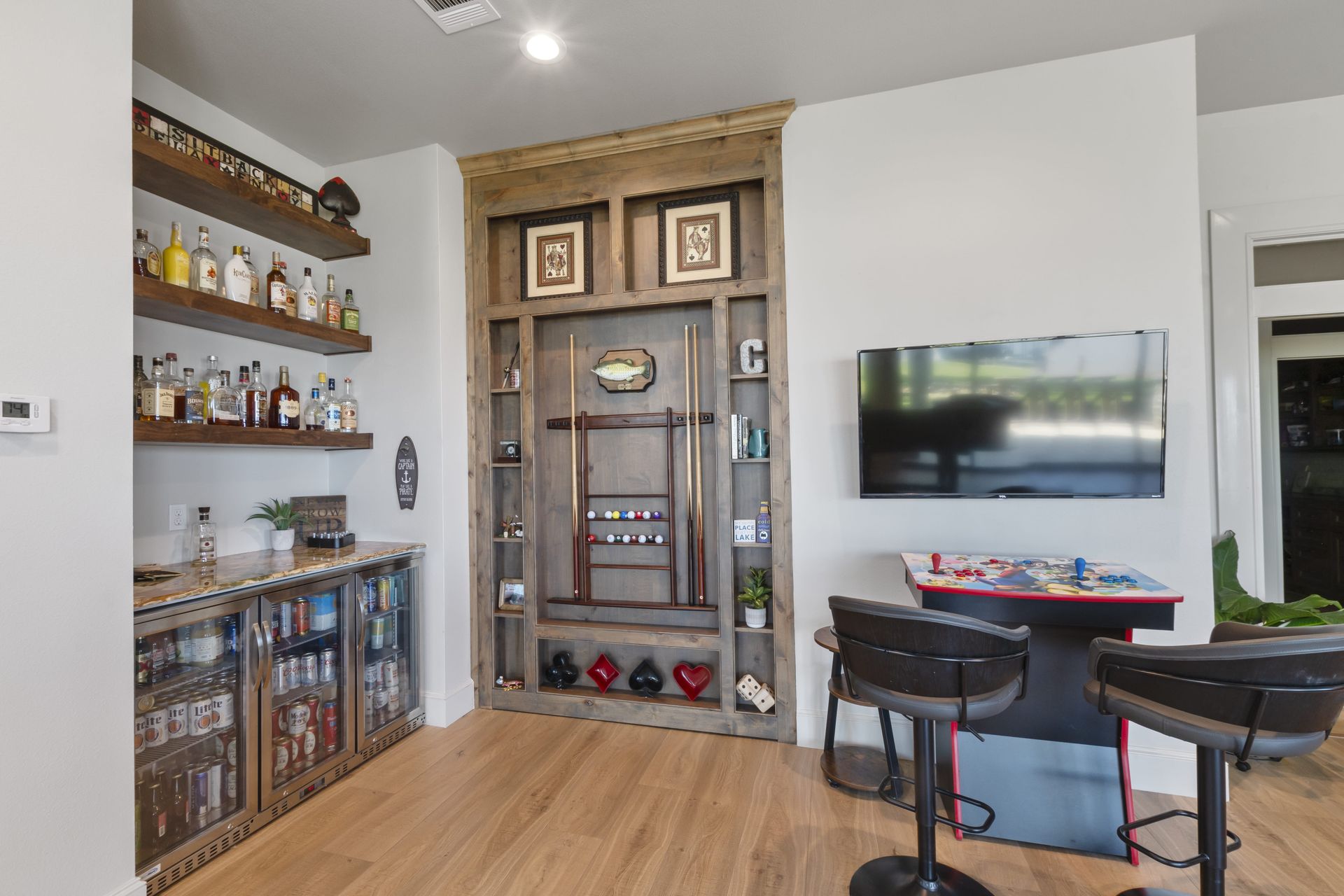 A home bar with a pool table and a television.