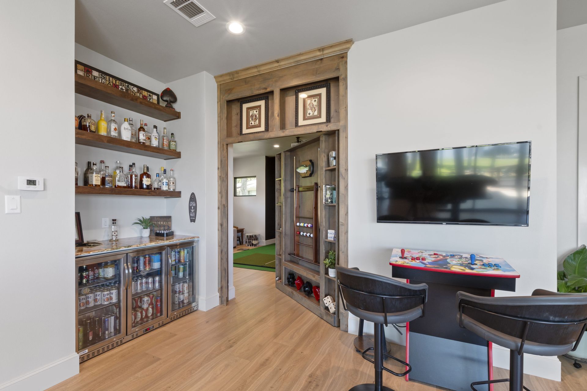A living room with a bar and a flat screen tv.