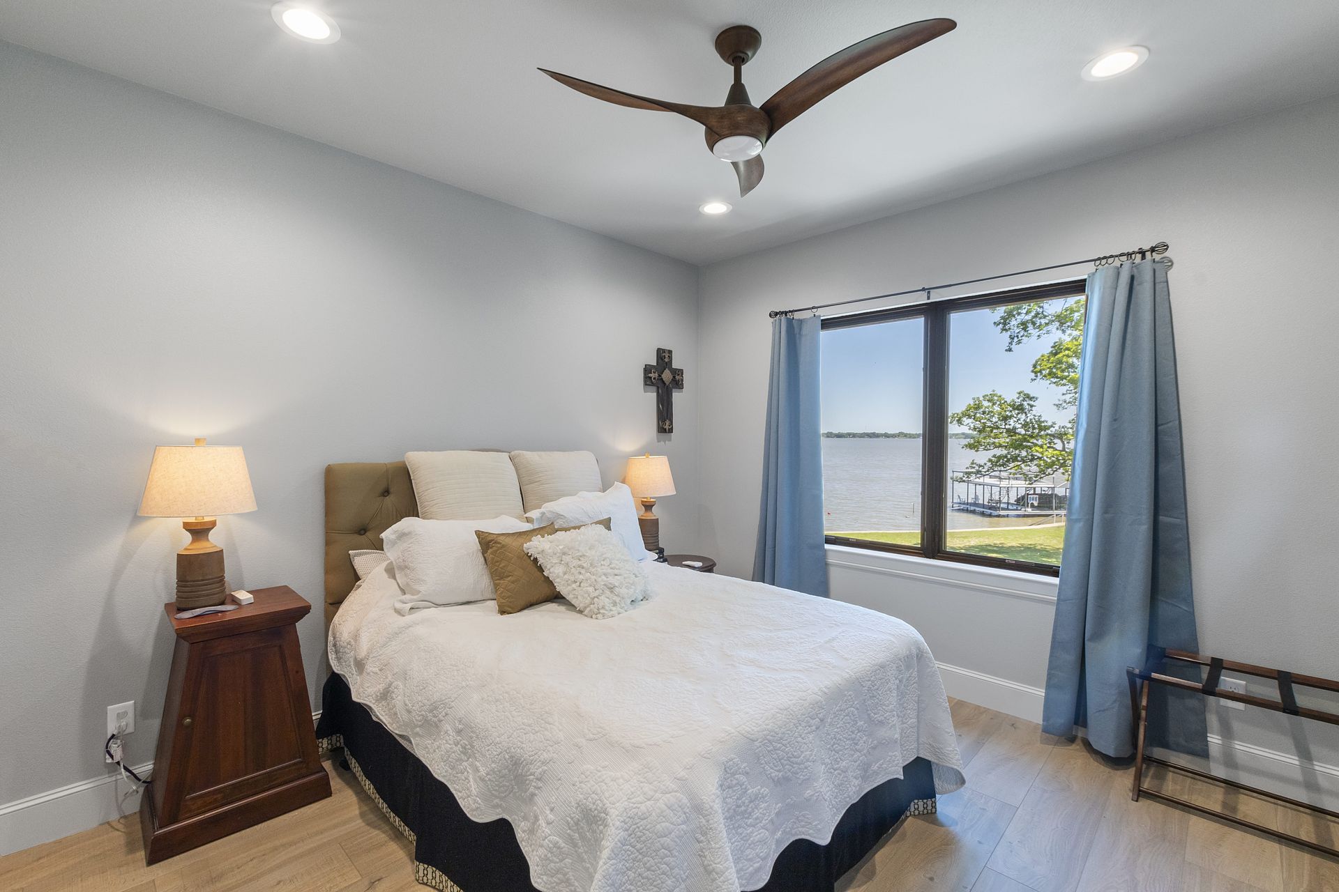 A bedroom with a large bed and a ceiling fan