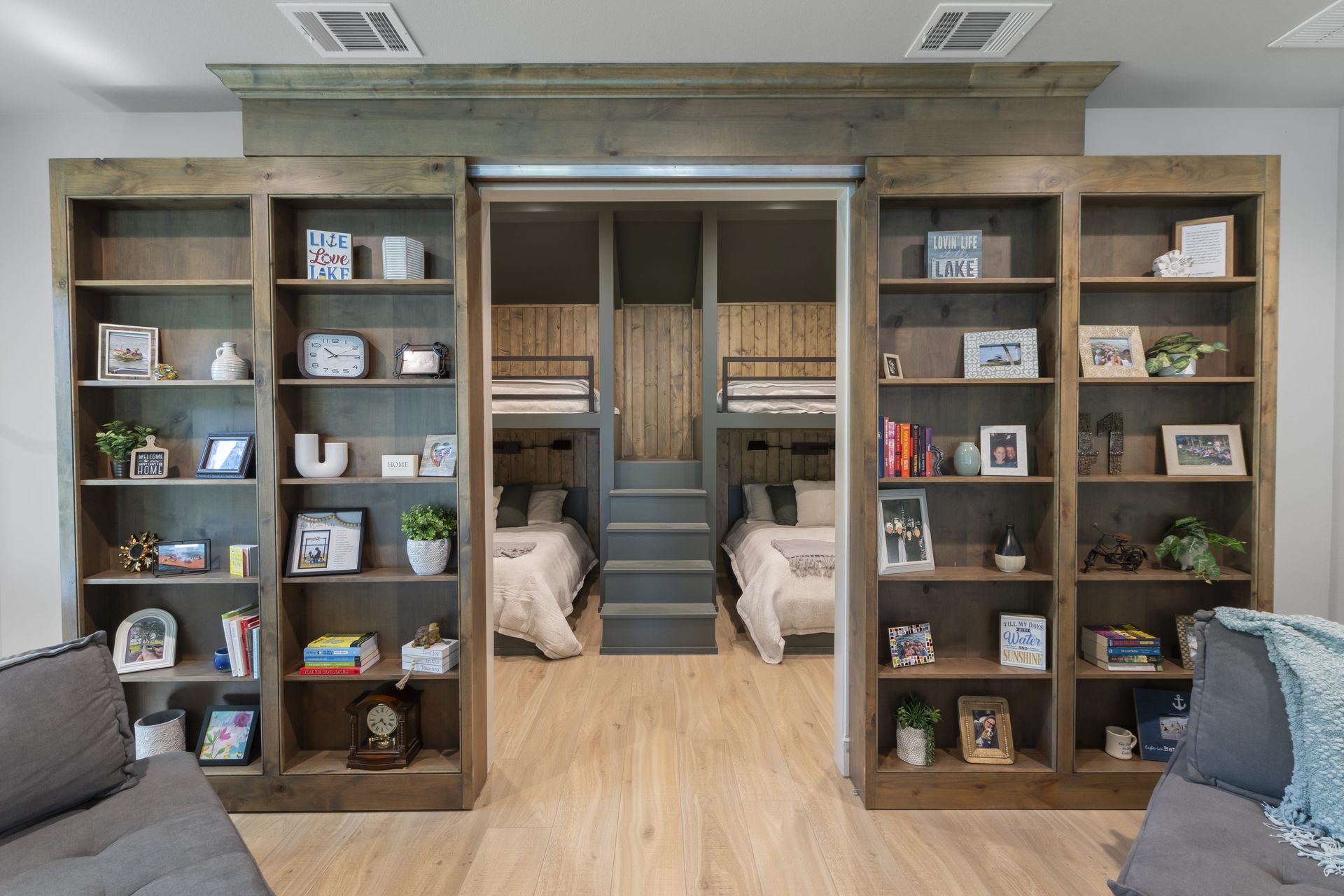 A living room with a couch , shelves , and bunk beds.