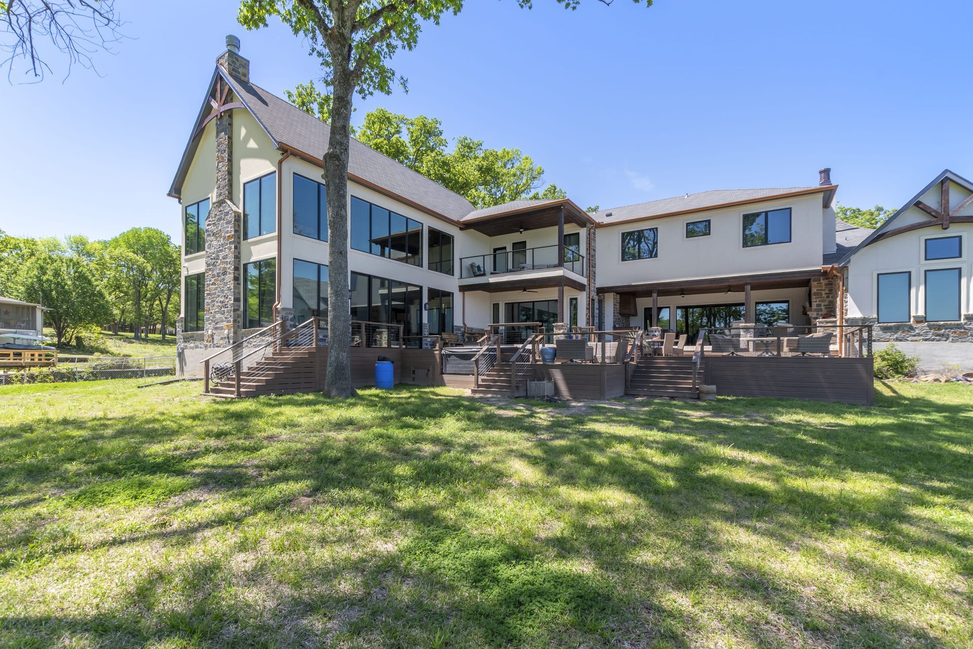 A large house with a lot of windows is sitting on top of a lush green field.