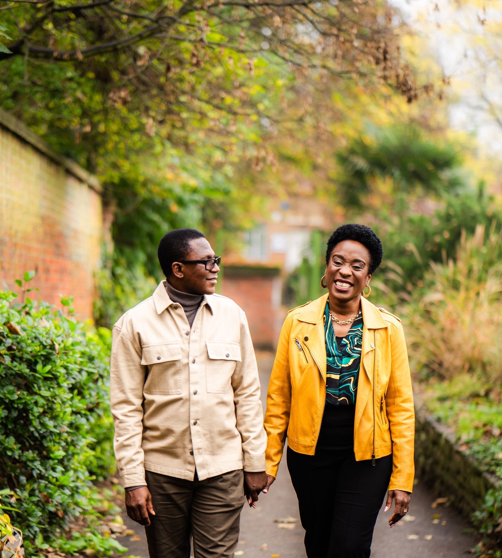 Tomi and Martins Toluhi are walking down a path holding hands.