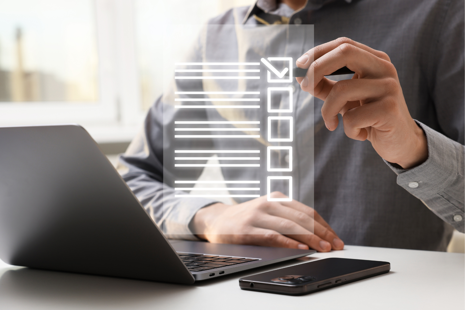 Person using a laptop and smartphone with a digital checklist overlay on screen