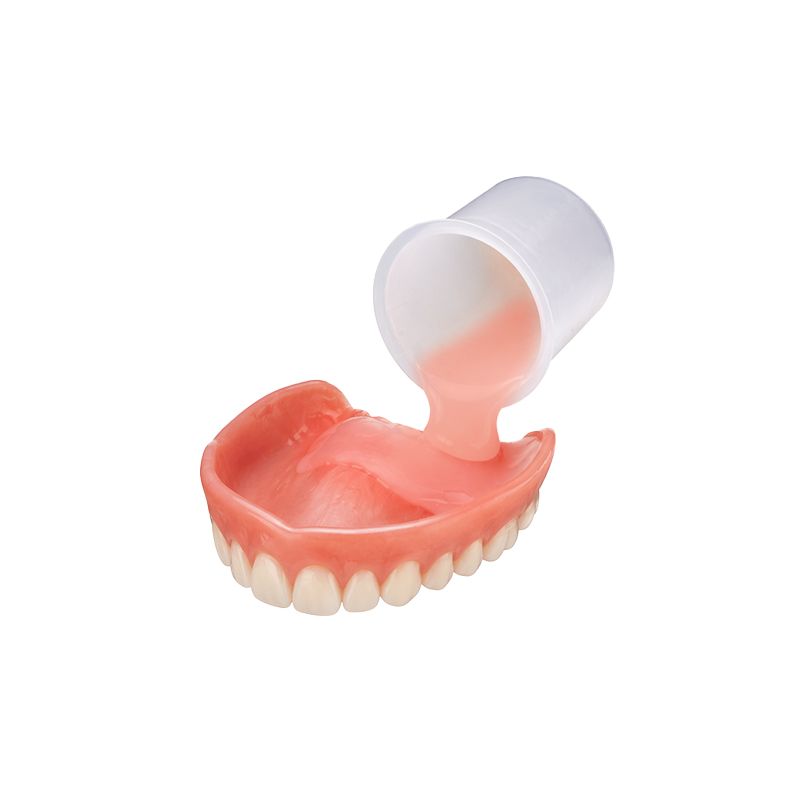 Dental model with a cup pouring pink putty into an upper denture mold