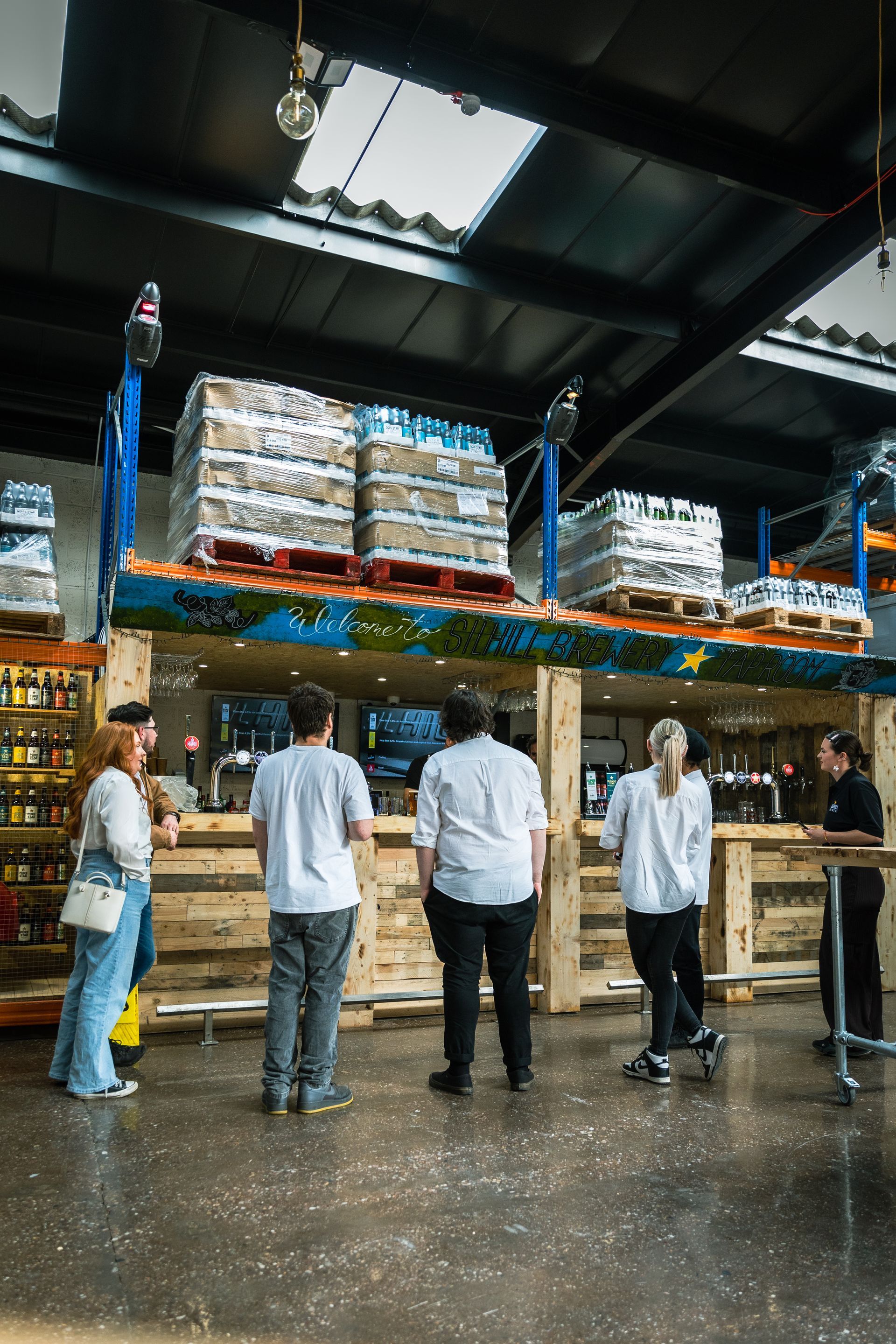 A group of people standing in front of a counter in a restaurant.