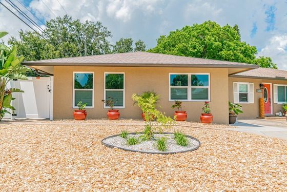 A house with a gravel driveway in front of it