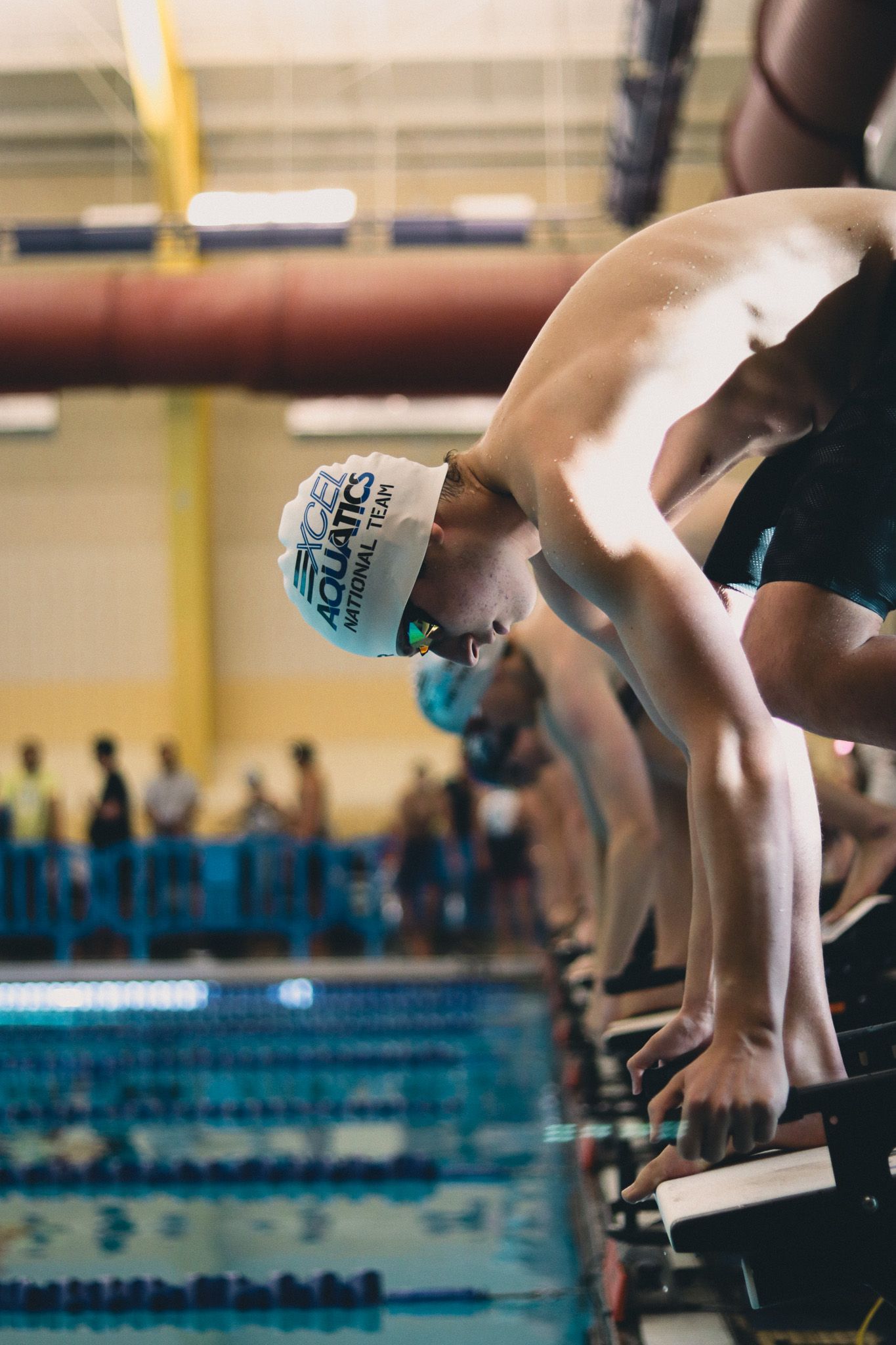 A member of the Excel Aquatics National team preparing to dive off the blocks.