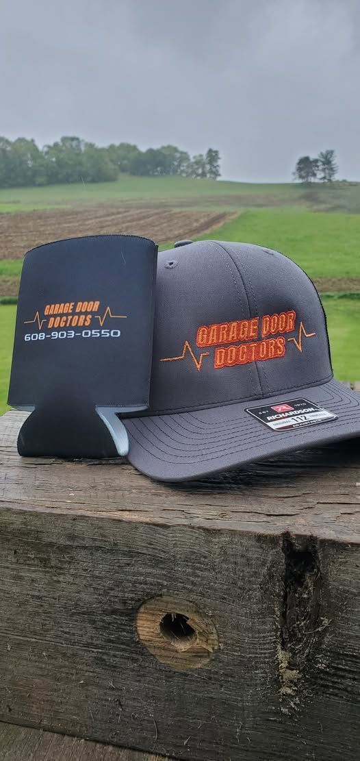 A hat and a cooler are sitting on a wooden fence.