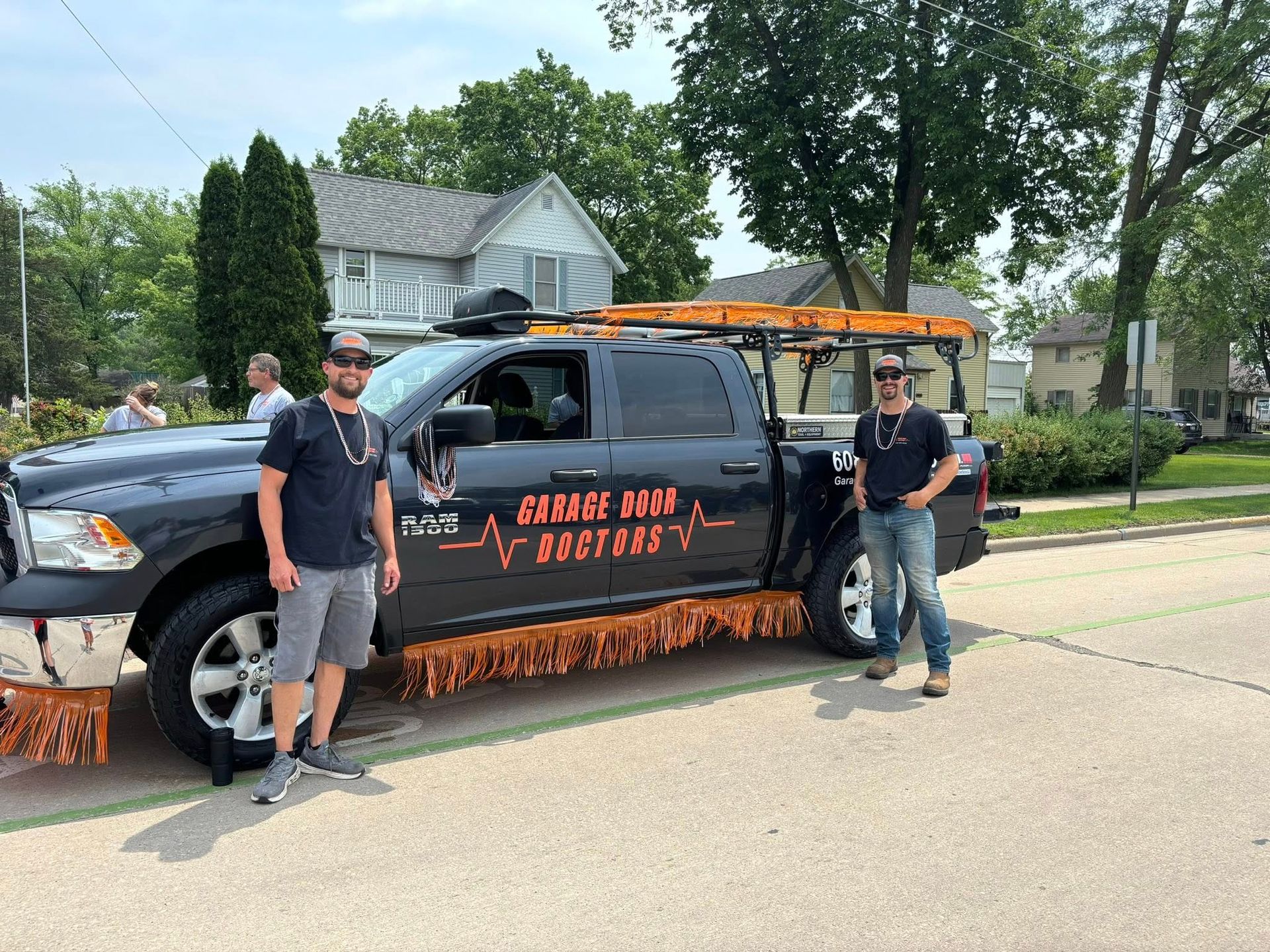 Two men are standing next to a truck on the side of the road.