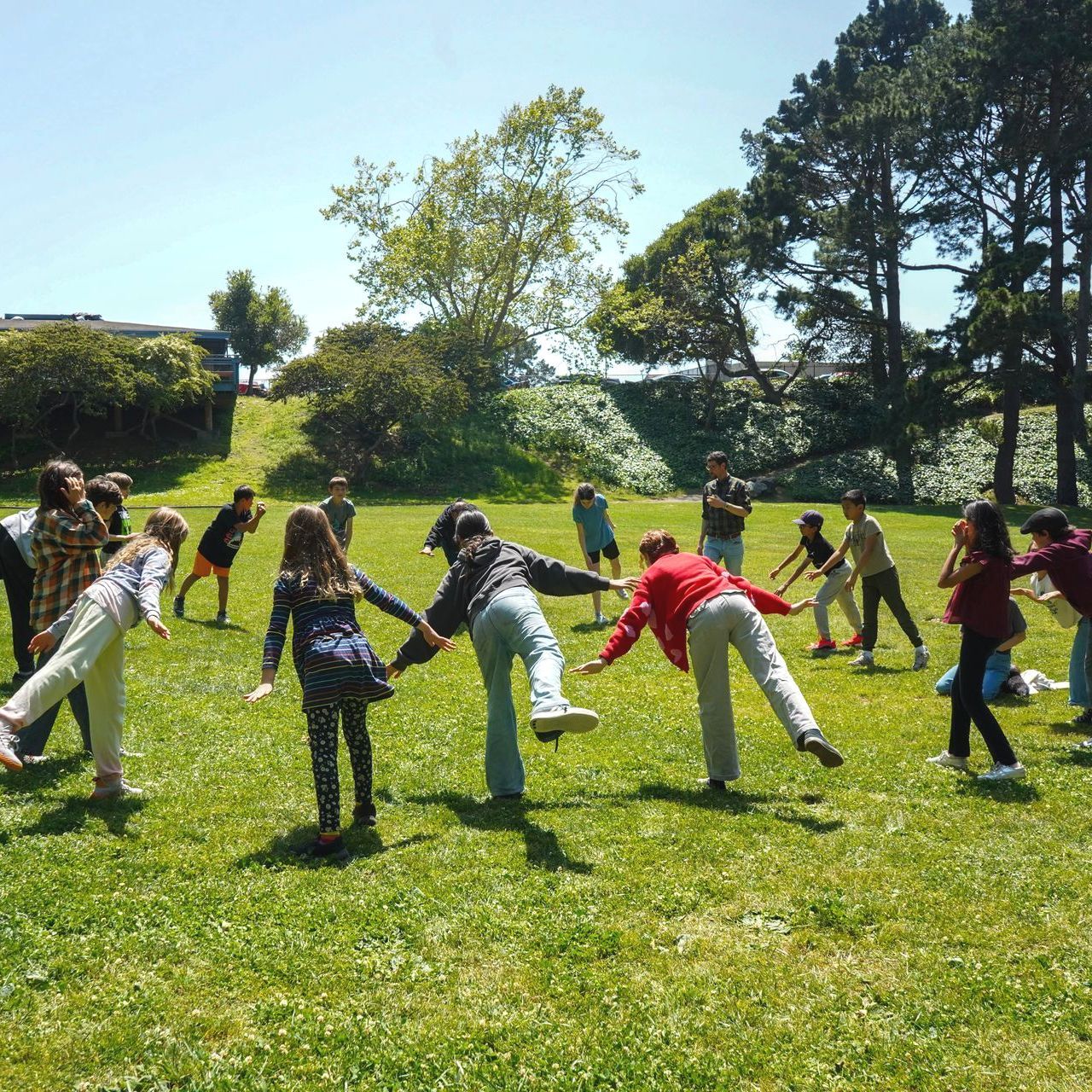 The Upper Elementary students join in some stretching and yoga before PE in the park.