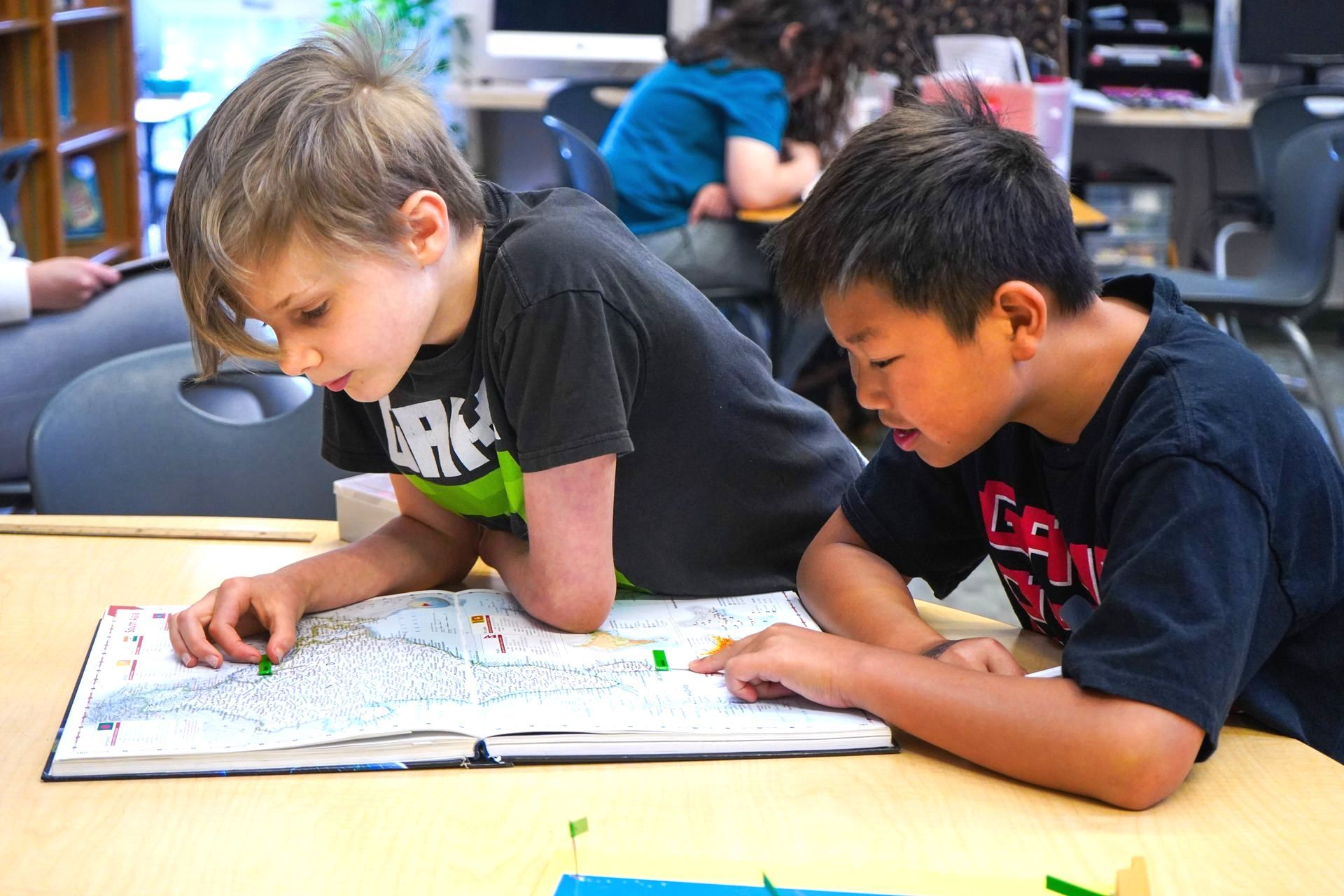 Two Upper Elementary students work together on a geography map with their Montessori map materials.