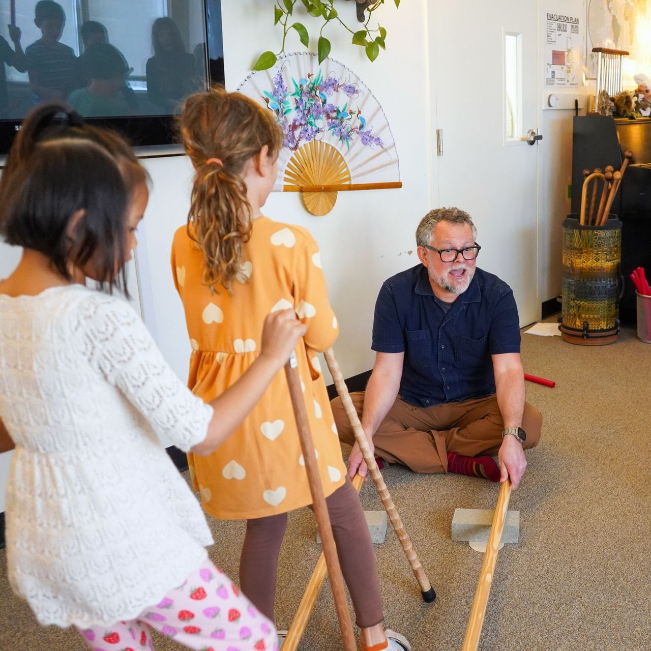 Two Lower Elementary students practice the movement portion of their song, with help from our Music Teacher.