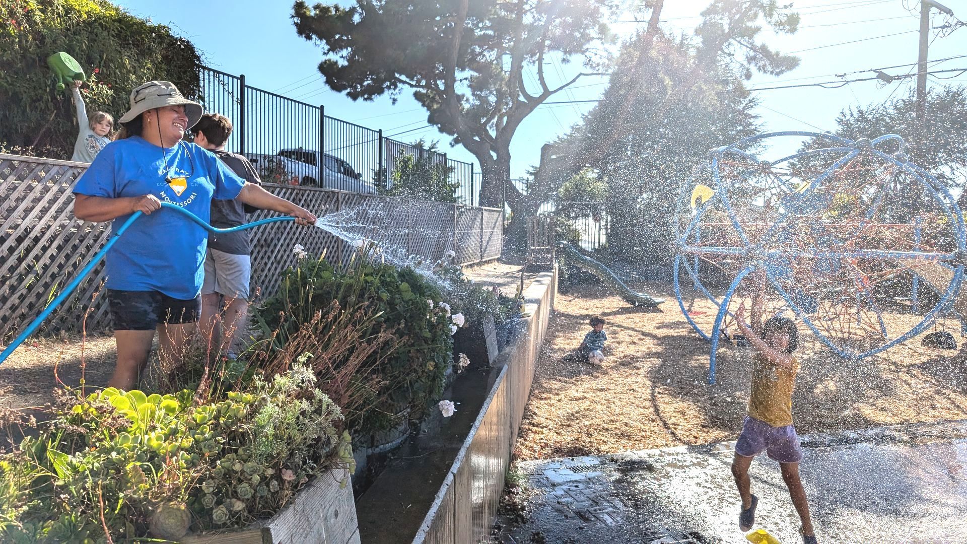 Students cool off on a hot day with a fun water spray from the hose!