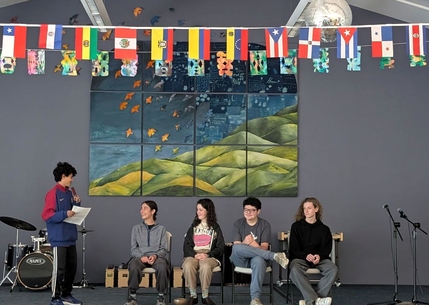 Four 8th Graders sit on stage and share with the entire school their favorite memories before graduating. 