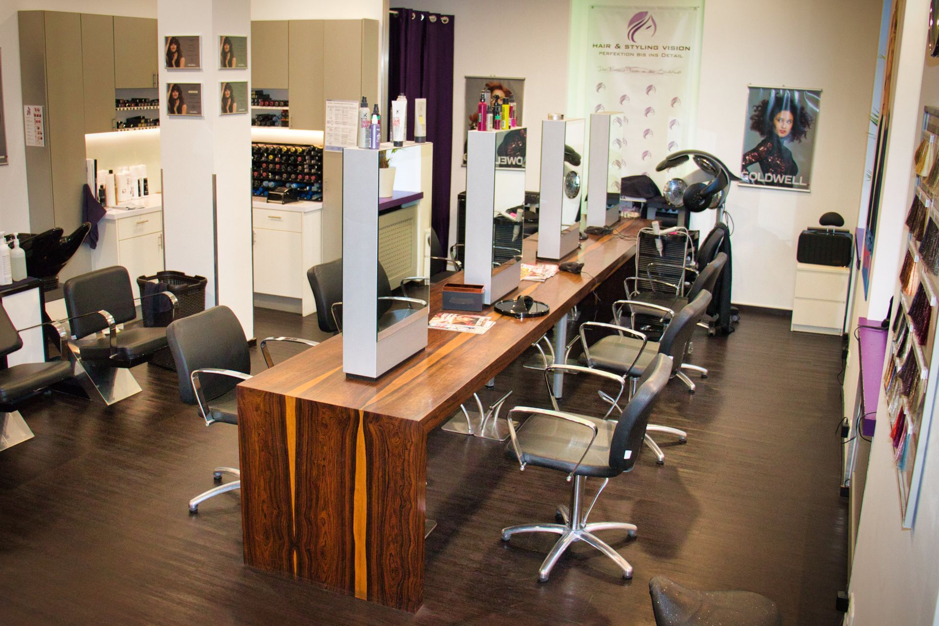 Ein Friseursalon mit einem langen Holztisch und Stühlen.