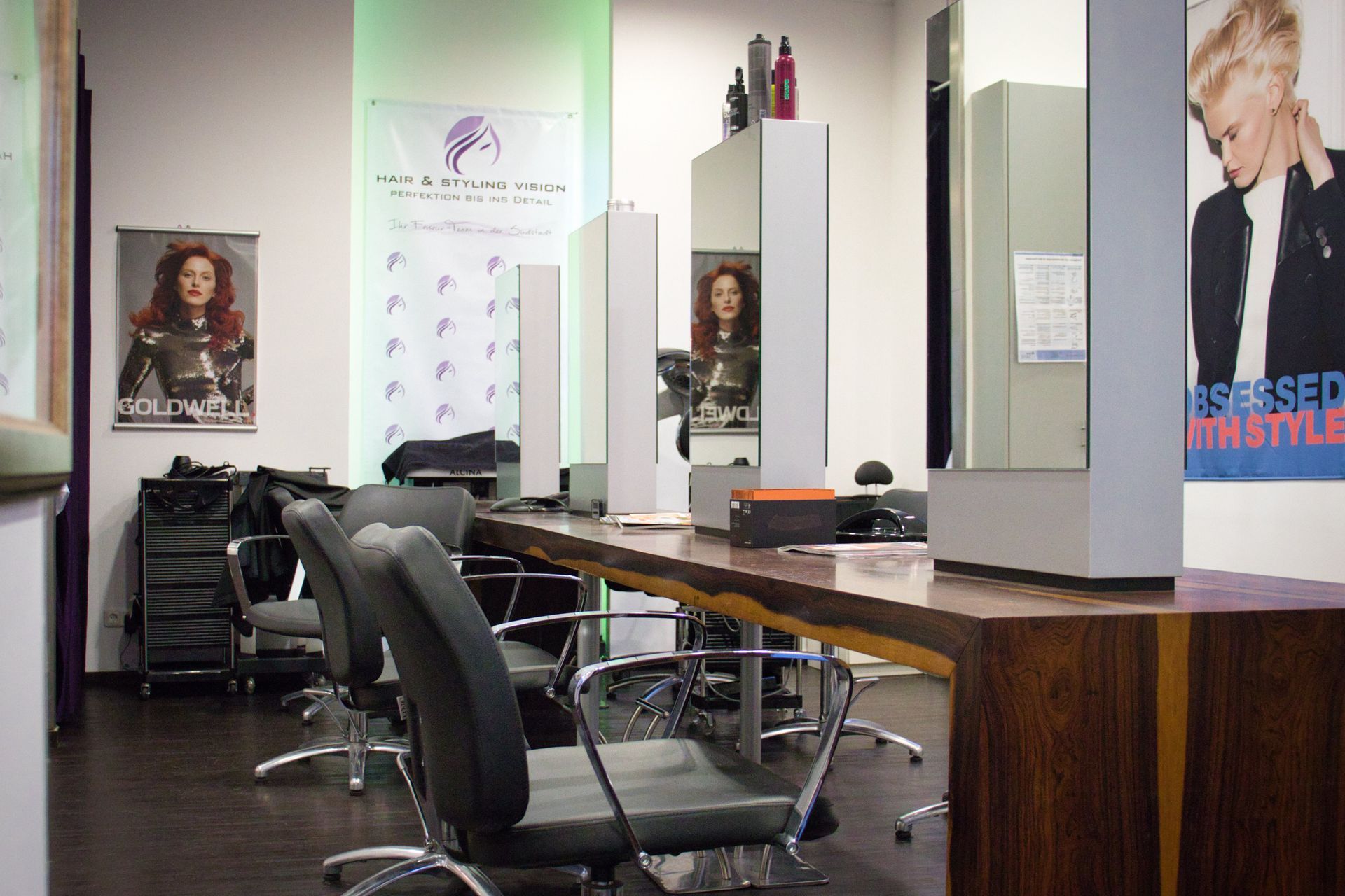 Ein Friseursalon mit einem Poster an der Wand, auf dem steht: „Besessen von Stil“