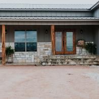 Stone-and-wood house facade with a covered porch and large windows