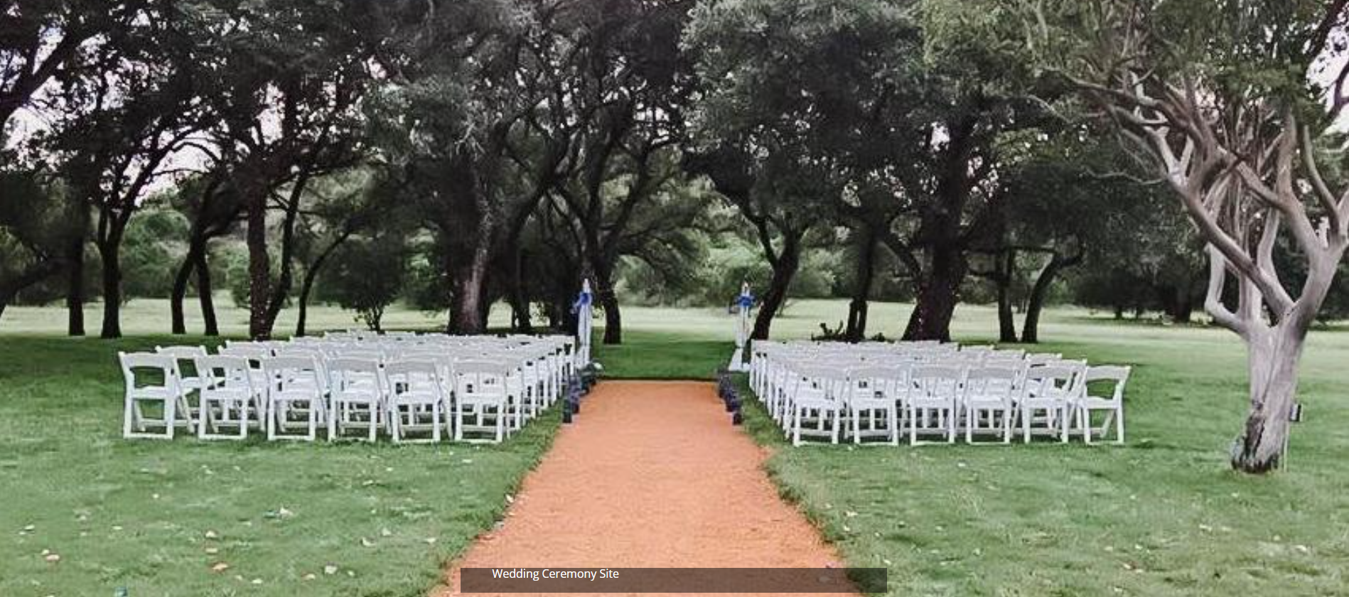 Outdoor wedding setup with white chairs lining an orange aisle in a tree-filled park
