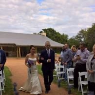 Bride and groom walking down an outdoor aisle at a wedding ceremony
