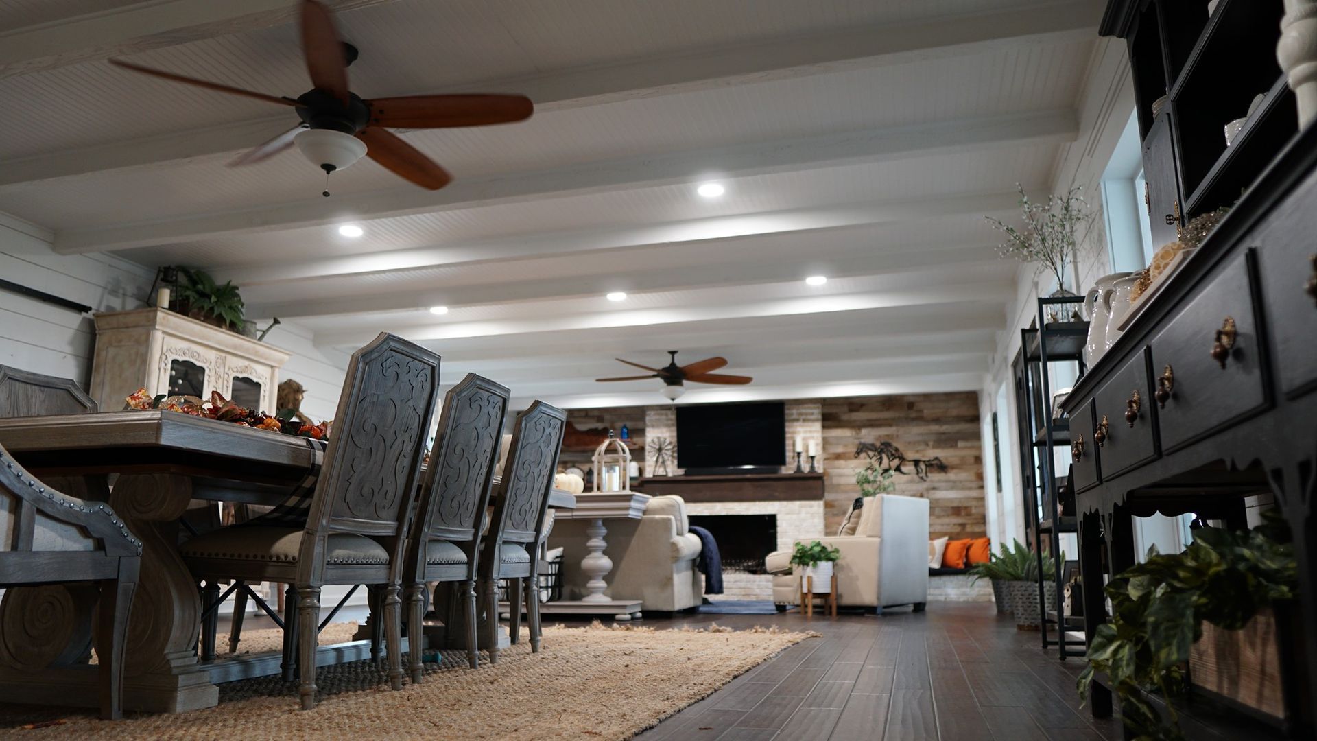 A living room with a table and chairs and a ceiling fan.