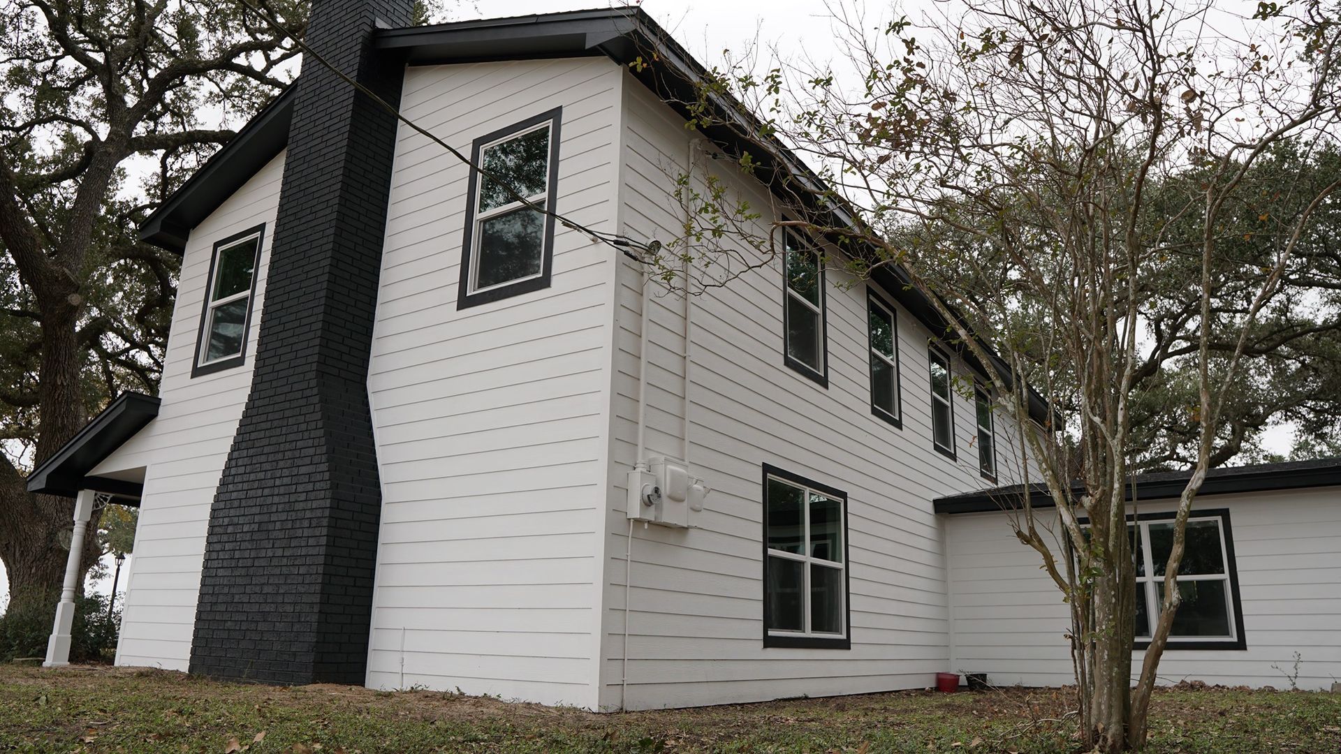 A white house with a black chimney on the side