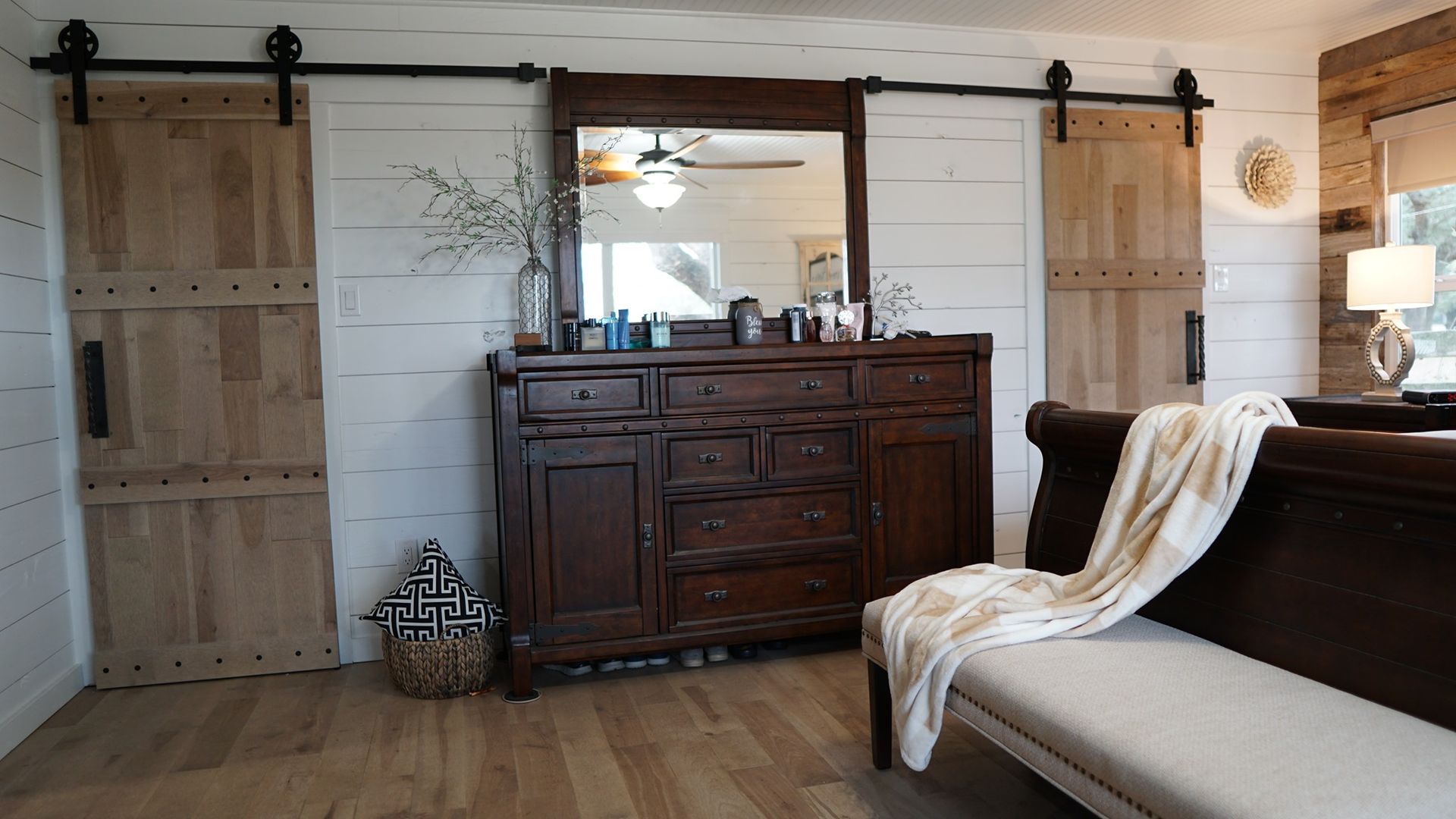 A living room with a dresser , mirror and sliding barn doors.