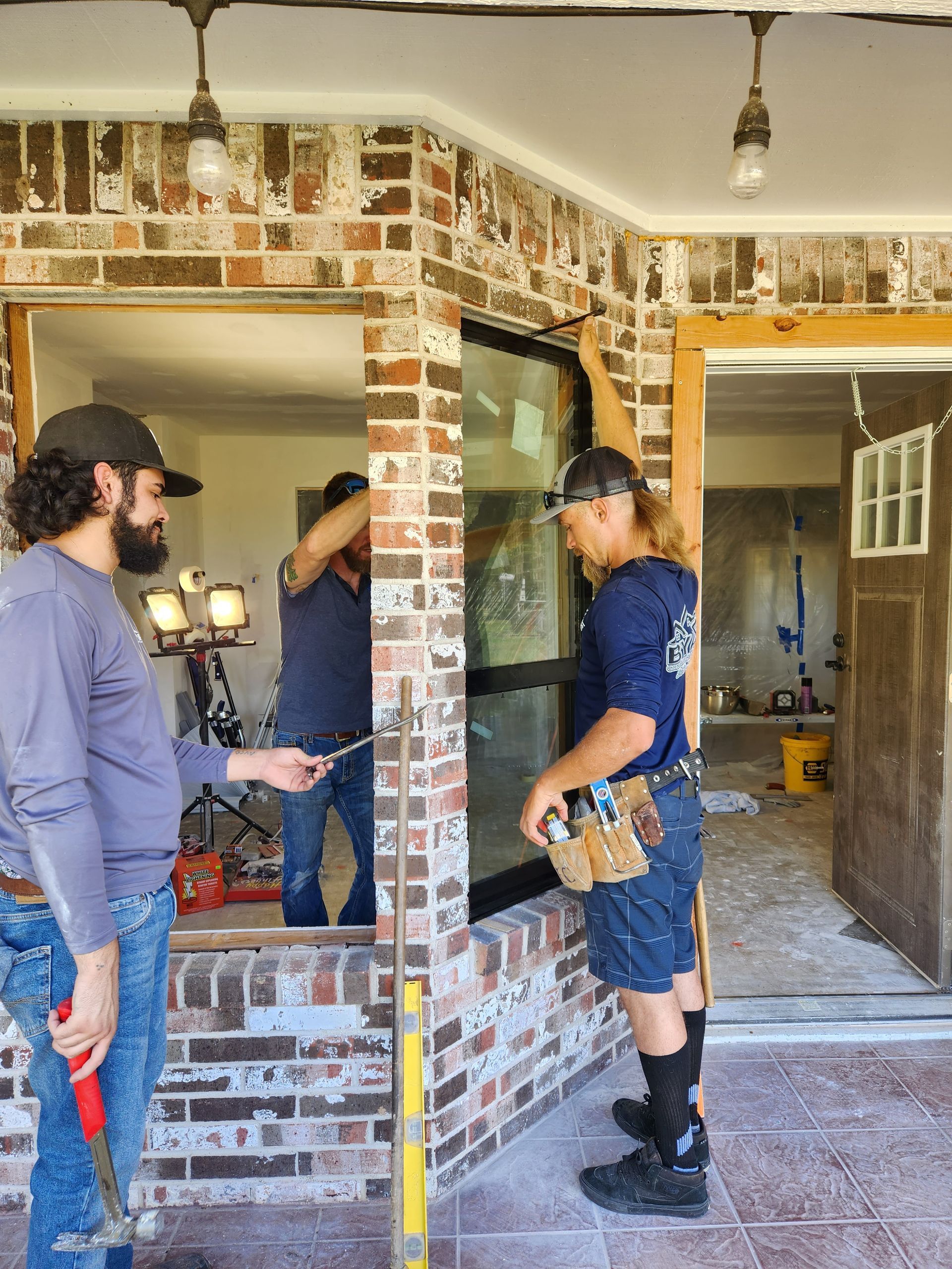 A group of men are working on a brick wall.