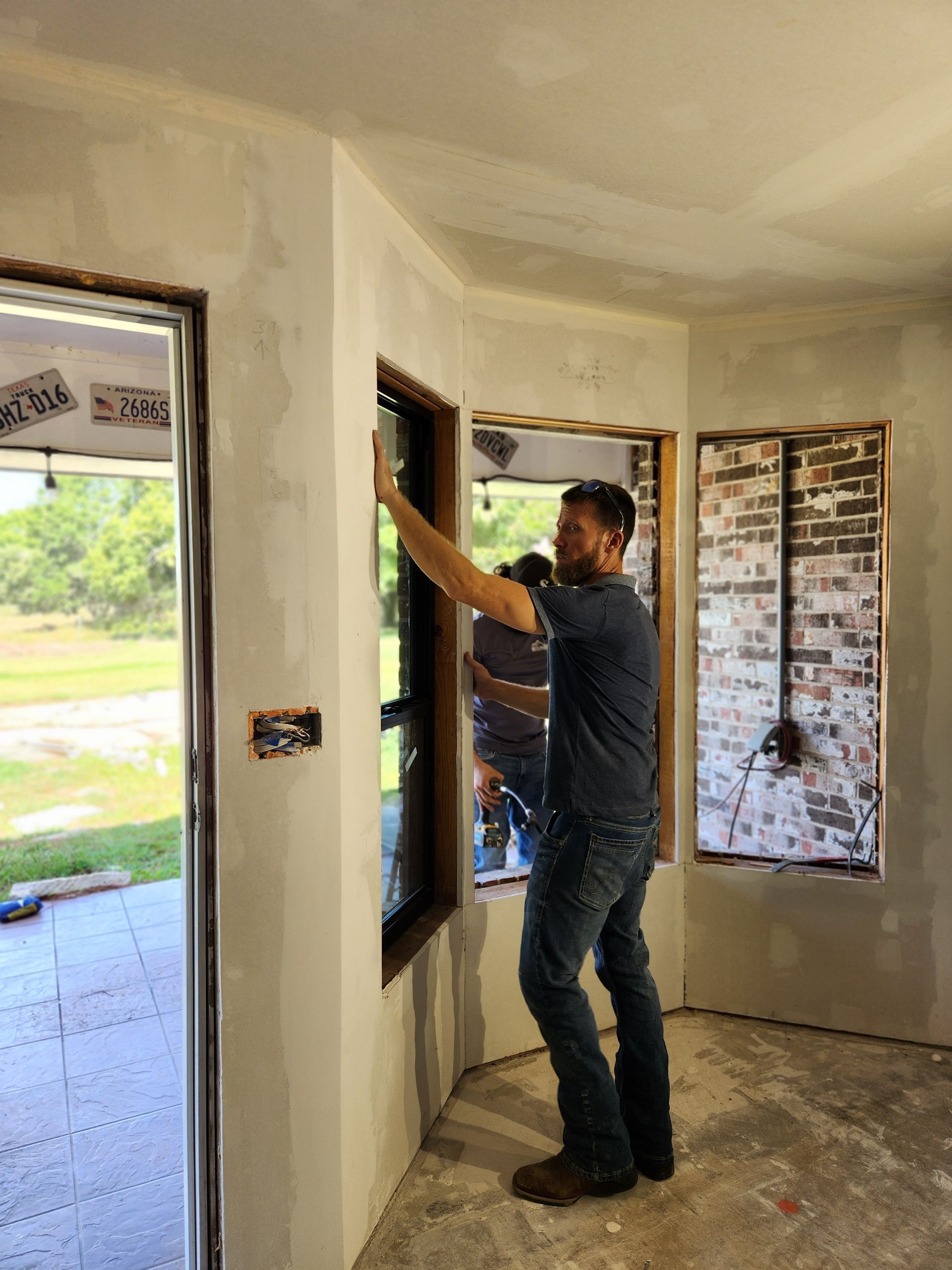 A man is installing a window in a room.