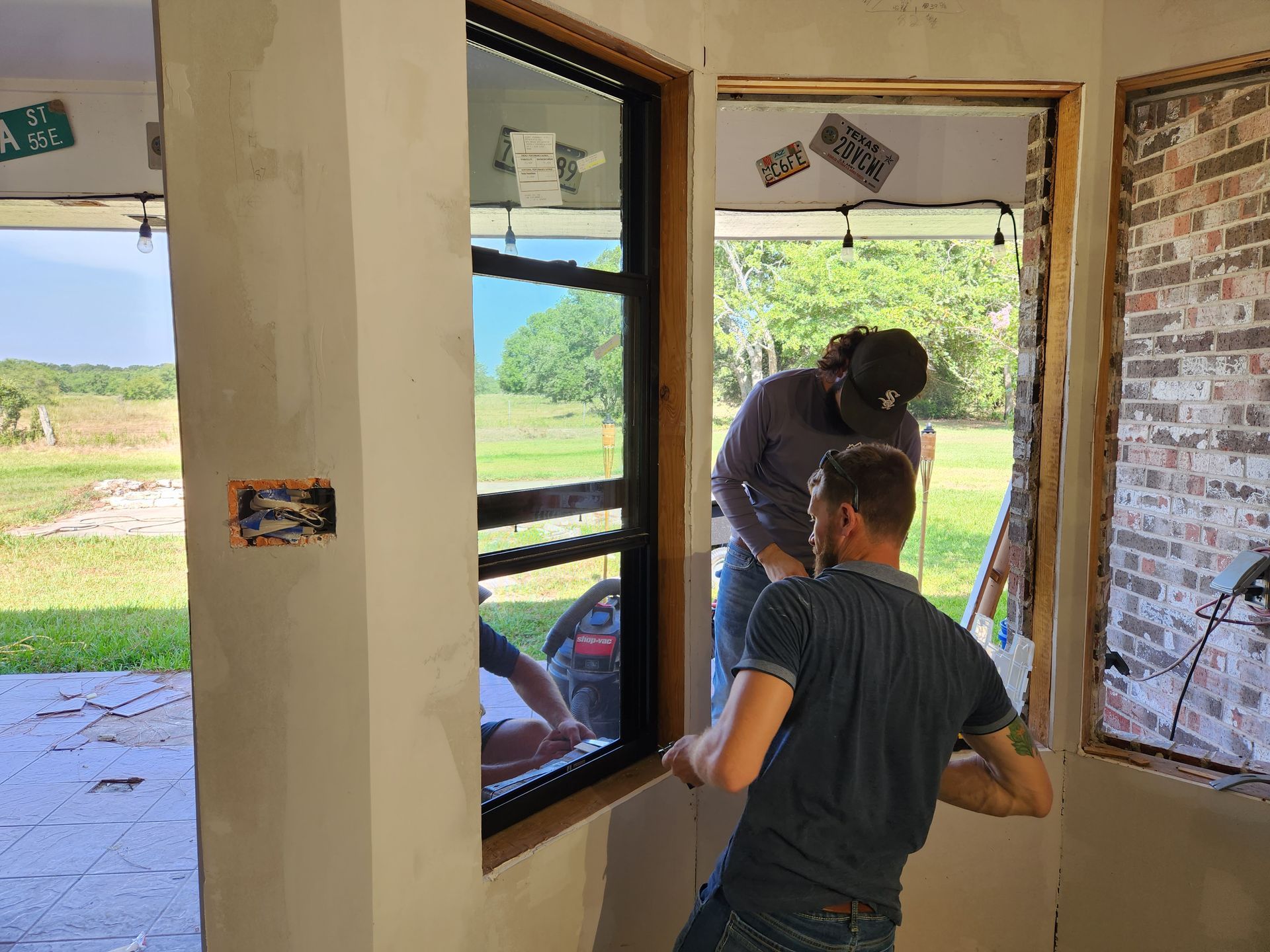 Two men are installing a window in a room.