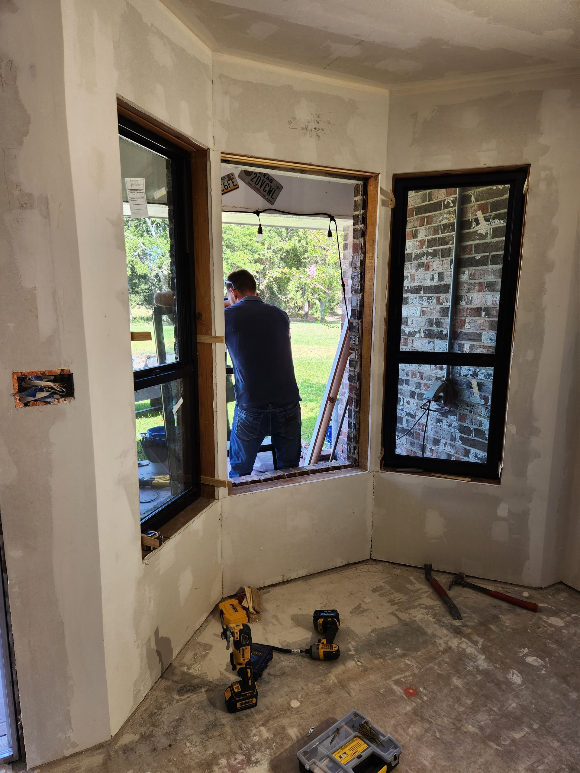 A man is working on a window in a room.