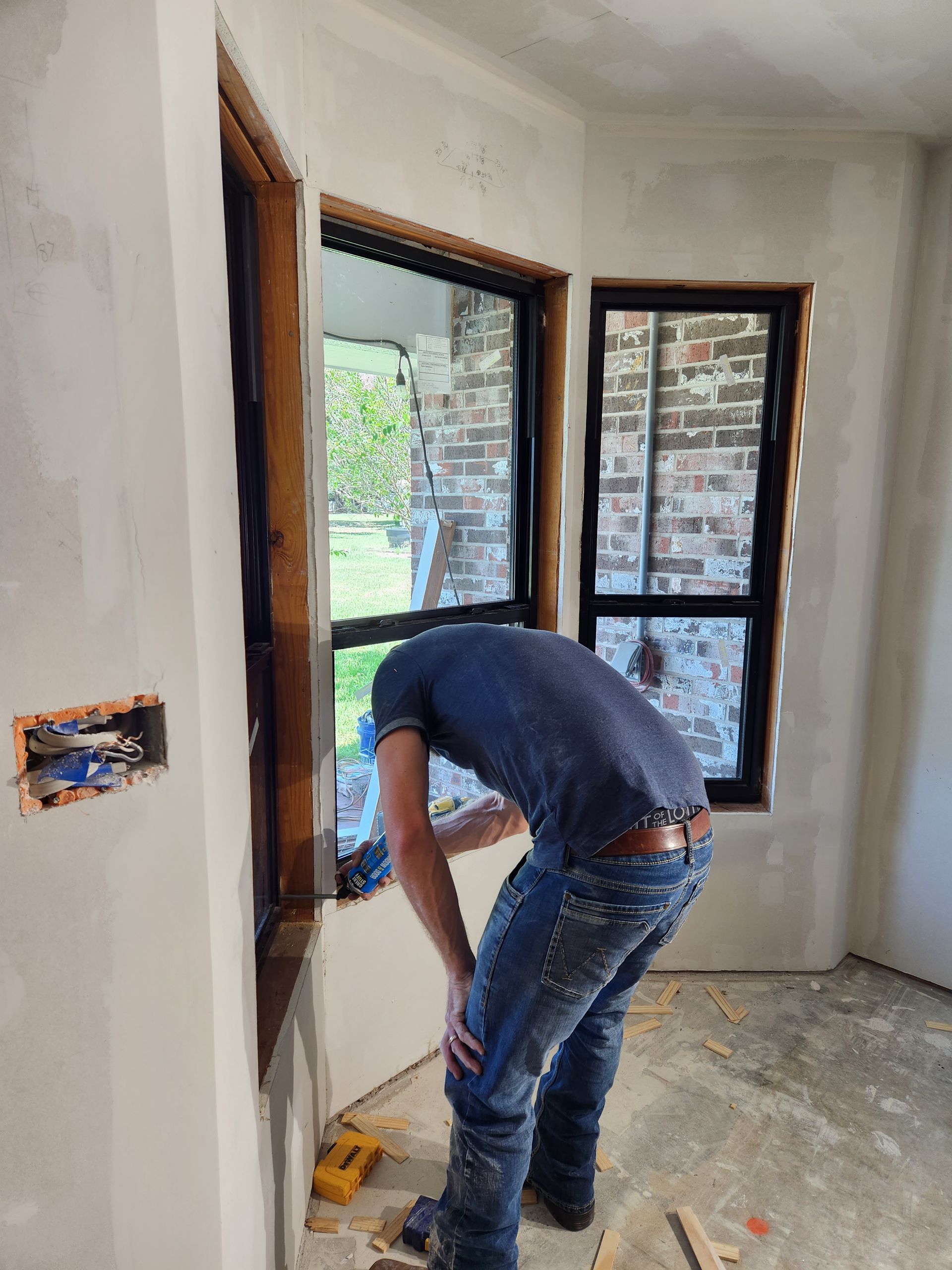 A man is working on a window in a room.