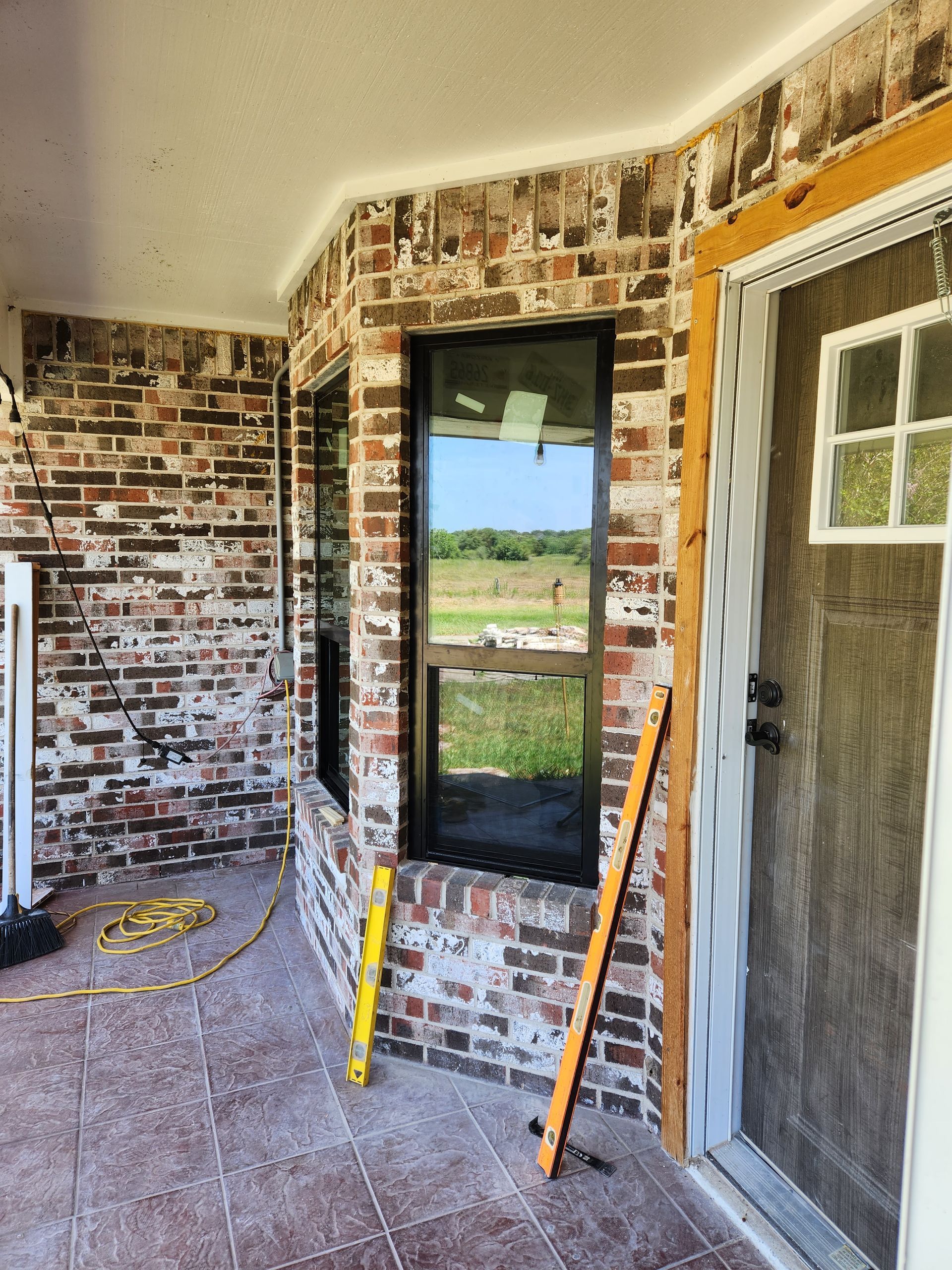 A brick wall with a door and a window with a level on it.