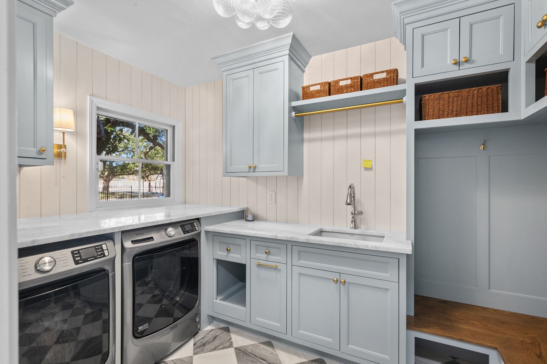 A laundry room with a washer and dryer , sink , and cabinets.