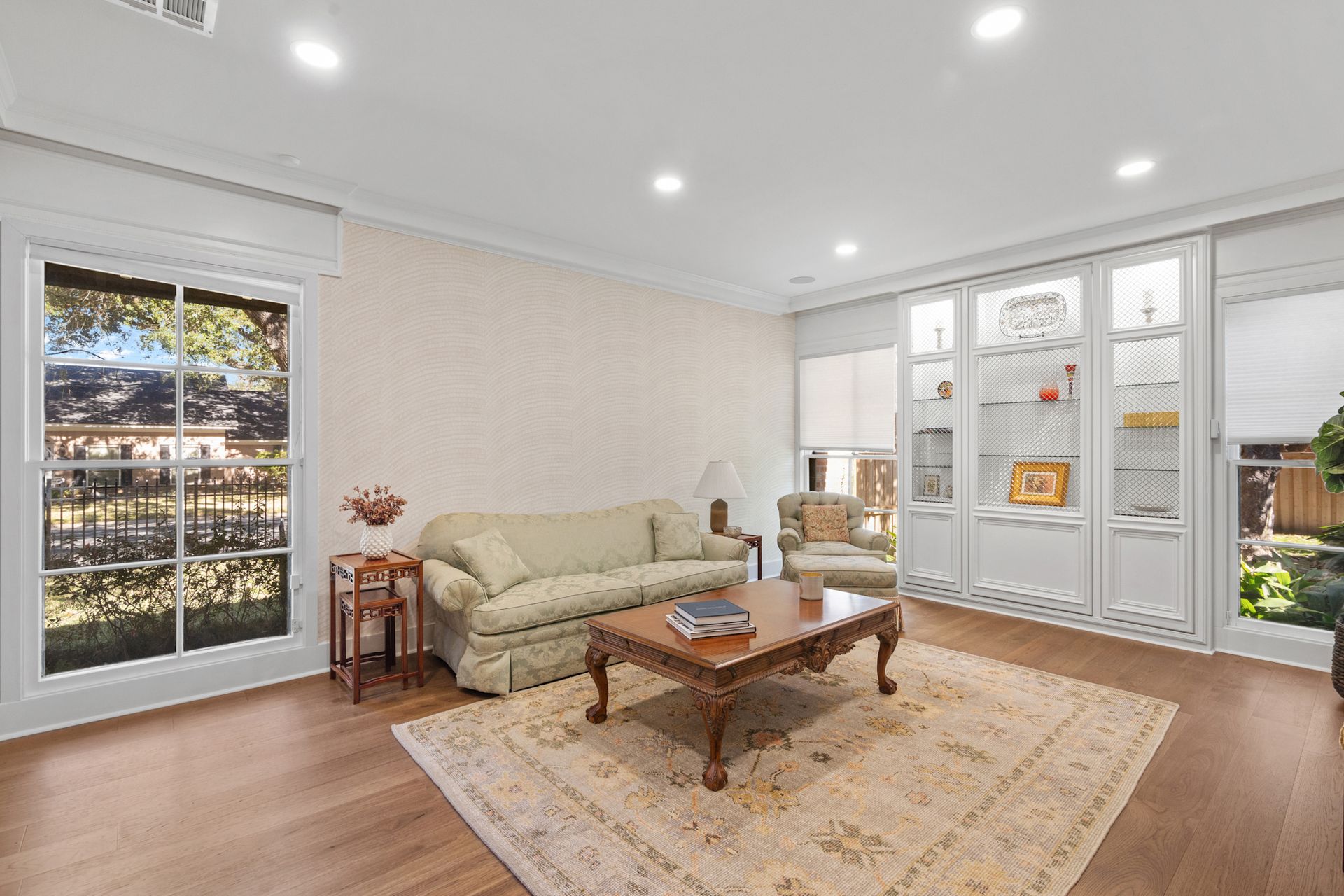 A living room with a couch , coffee table , chairs and a rug.