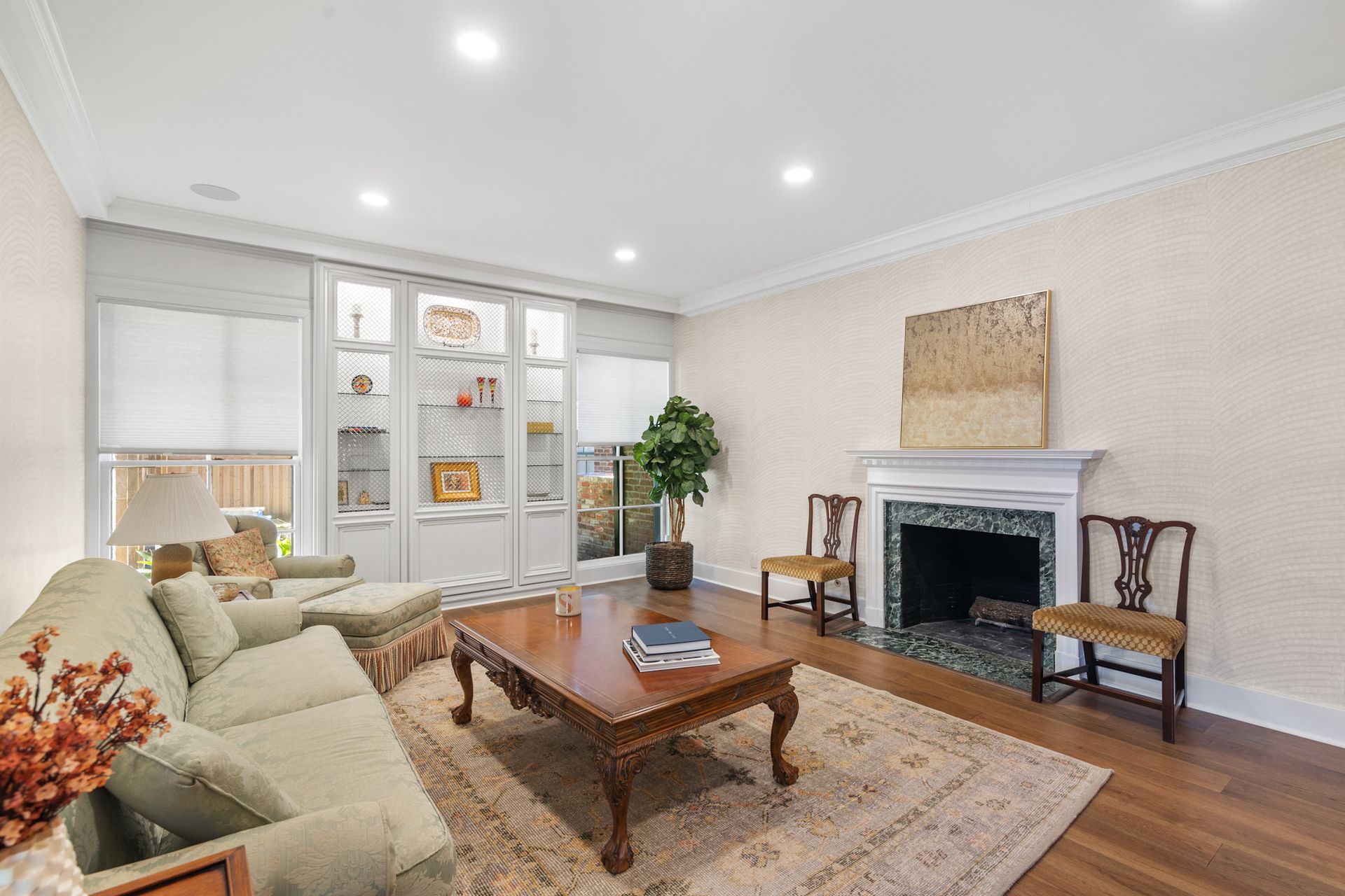 A living room with a couch , coffee table , chairs and a fireplace.